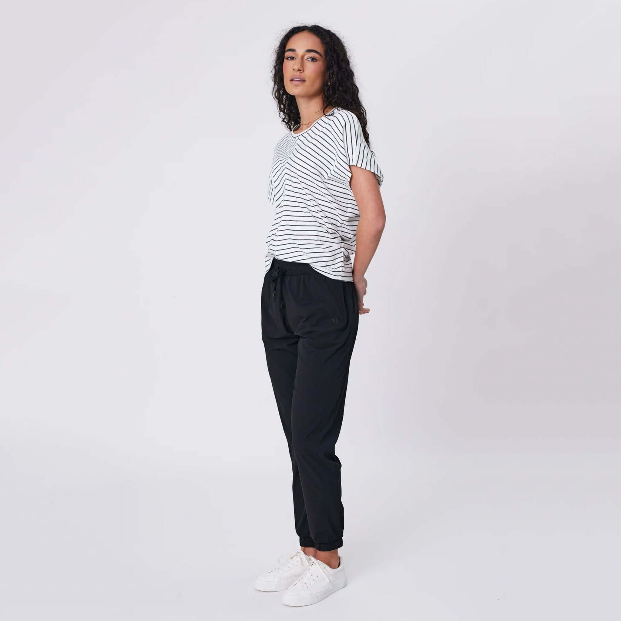 Marlow Travel Pants - Black on model, tapered leg travel pants with elastic drawstring waist and zip pockets