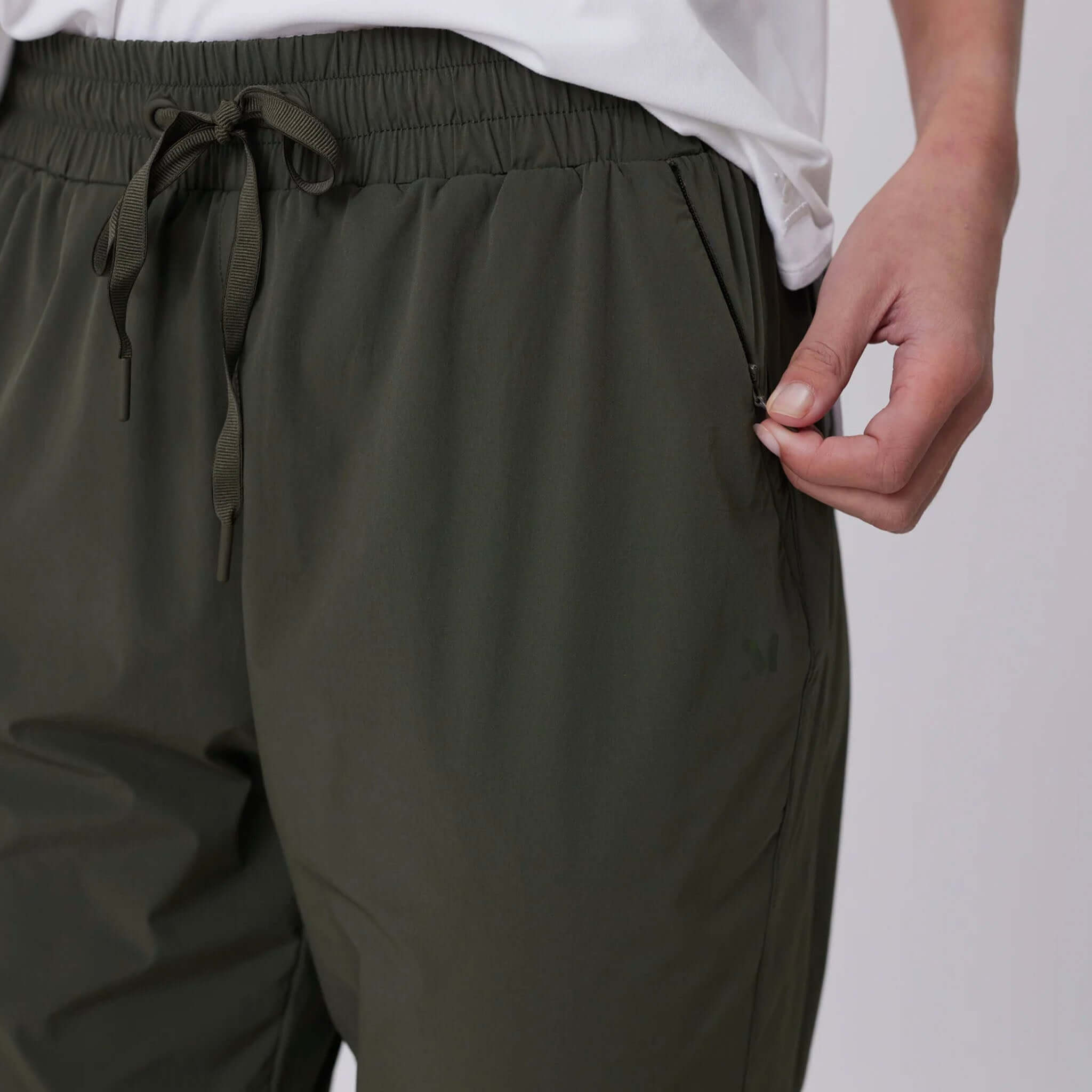 Alt Tag: Marlow Travel Pants - Olive close-up of elastic drawstring waistband and zip pocket in featherlight stretch fabric