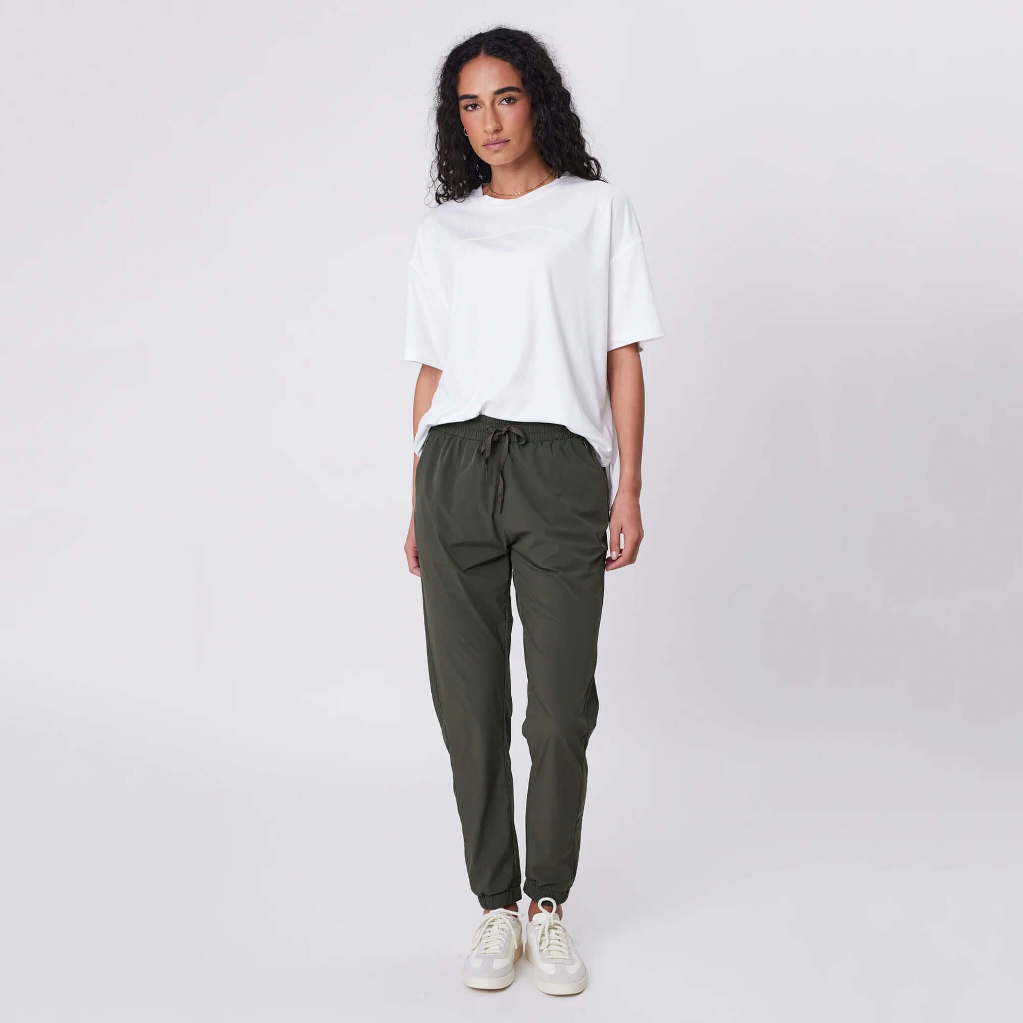 Marlow Travel Pants - Olive on model, featherlight stretch tapered leg travel pants with drawstring waist and zip pockets