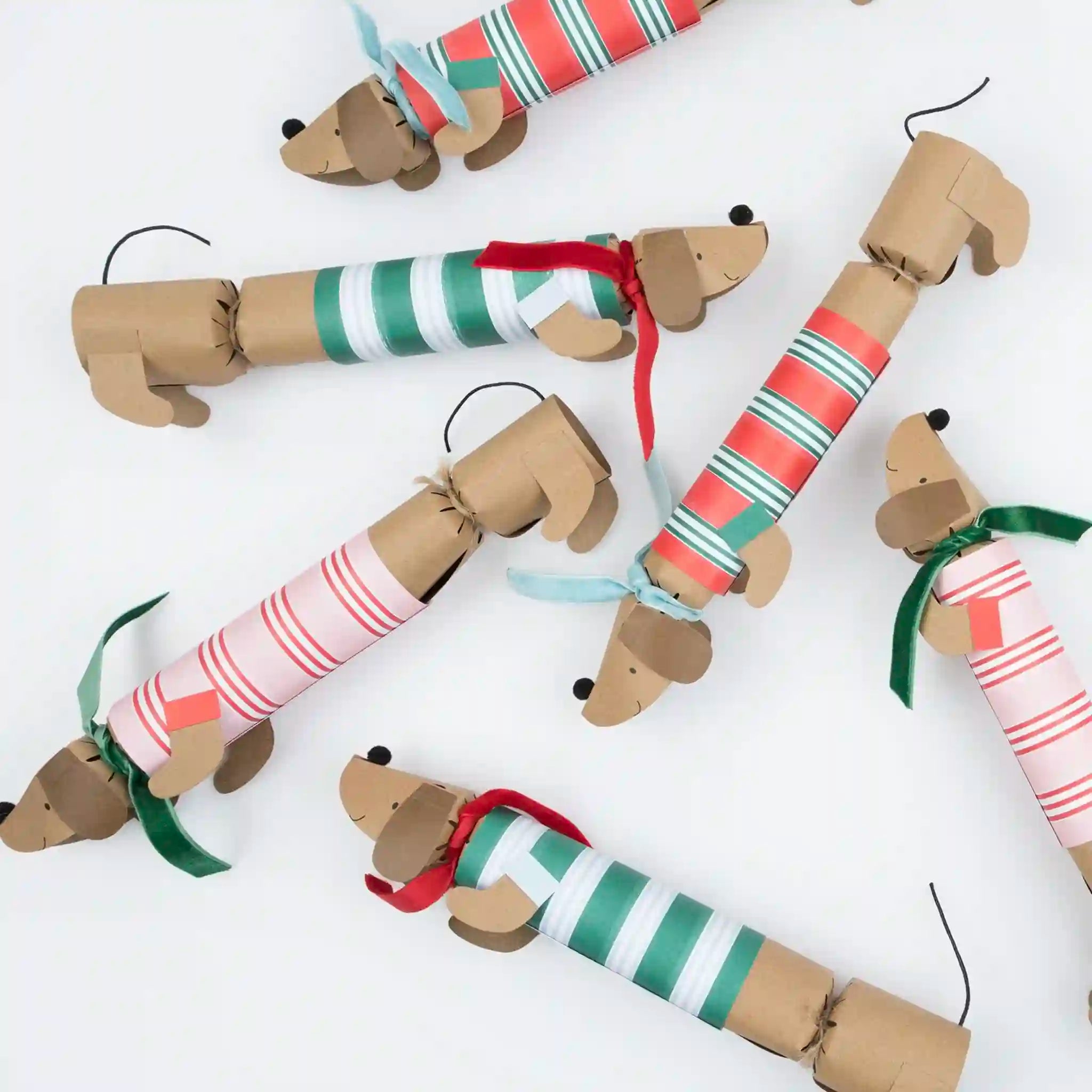 Cardboard dog ornaments with striped ties on a white background