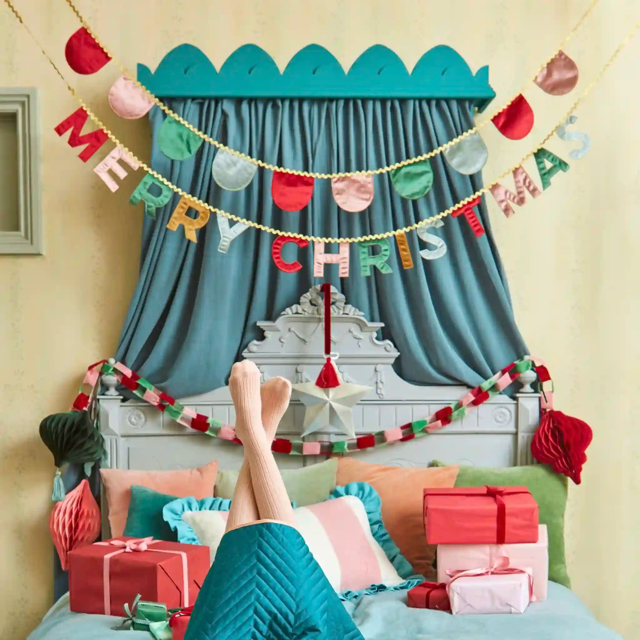 Decorated room with Christmas decorations, including a 'Merry Chris' banner and presents.