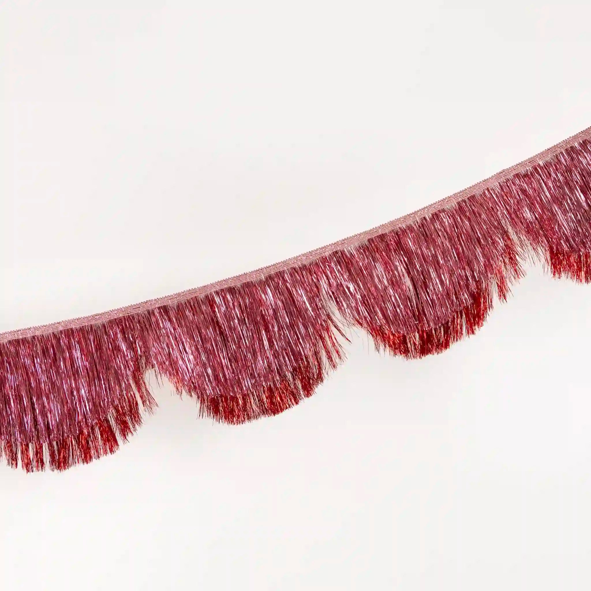 Close-up of a pink metallic fringe garland on a white background
