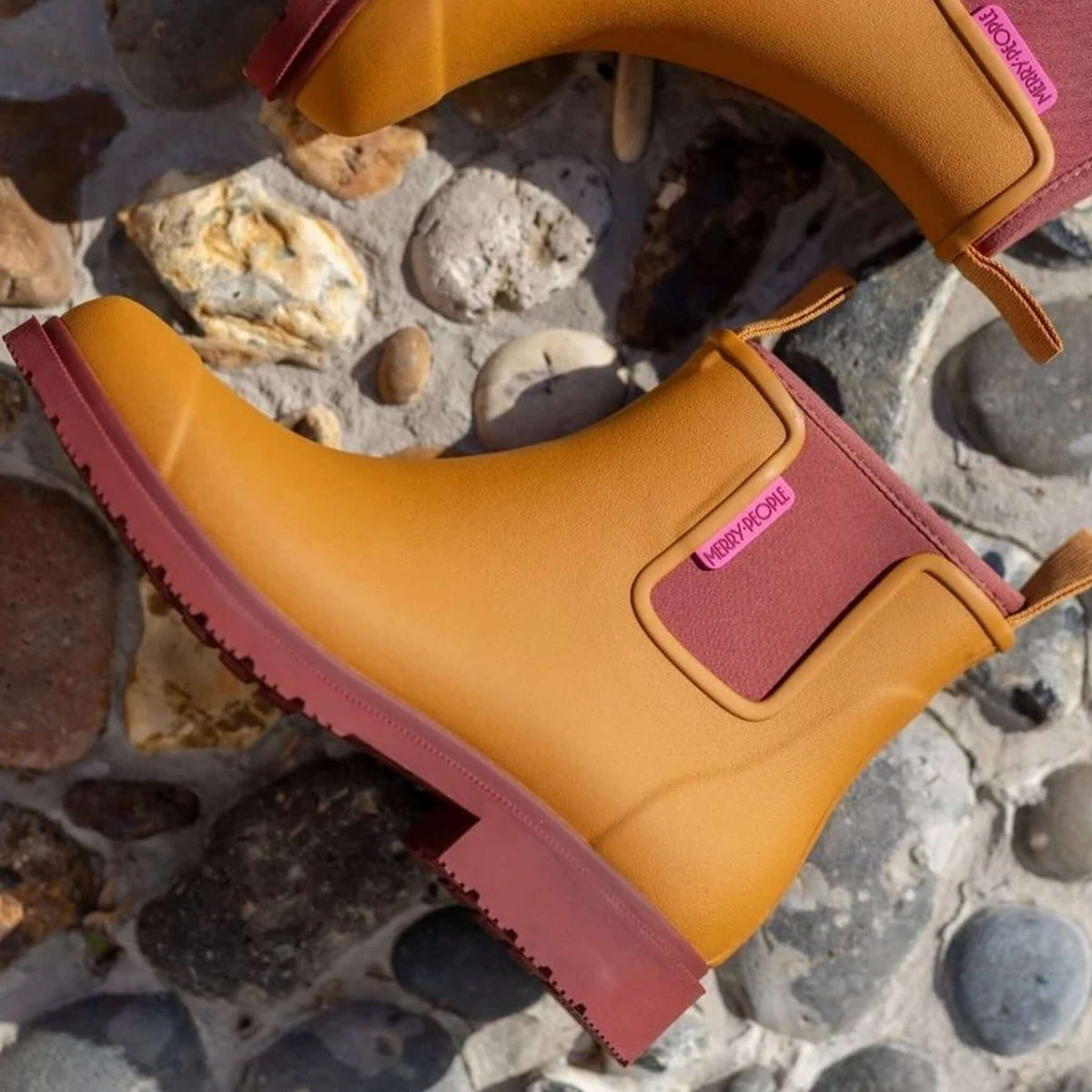Merry People Bobbi Ankle Boots - Ochre displayed on a stone surface showcasing their stylish design.