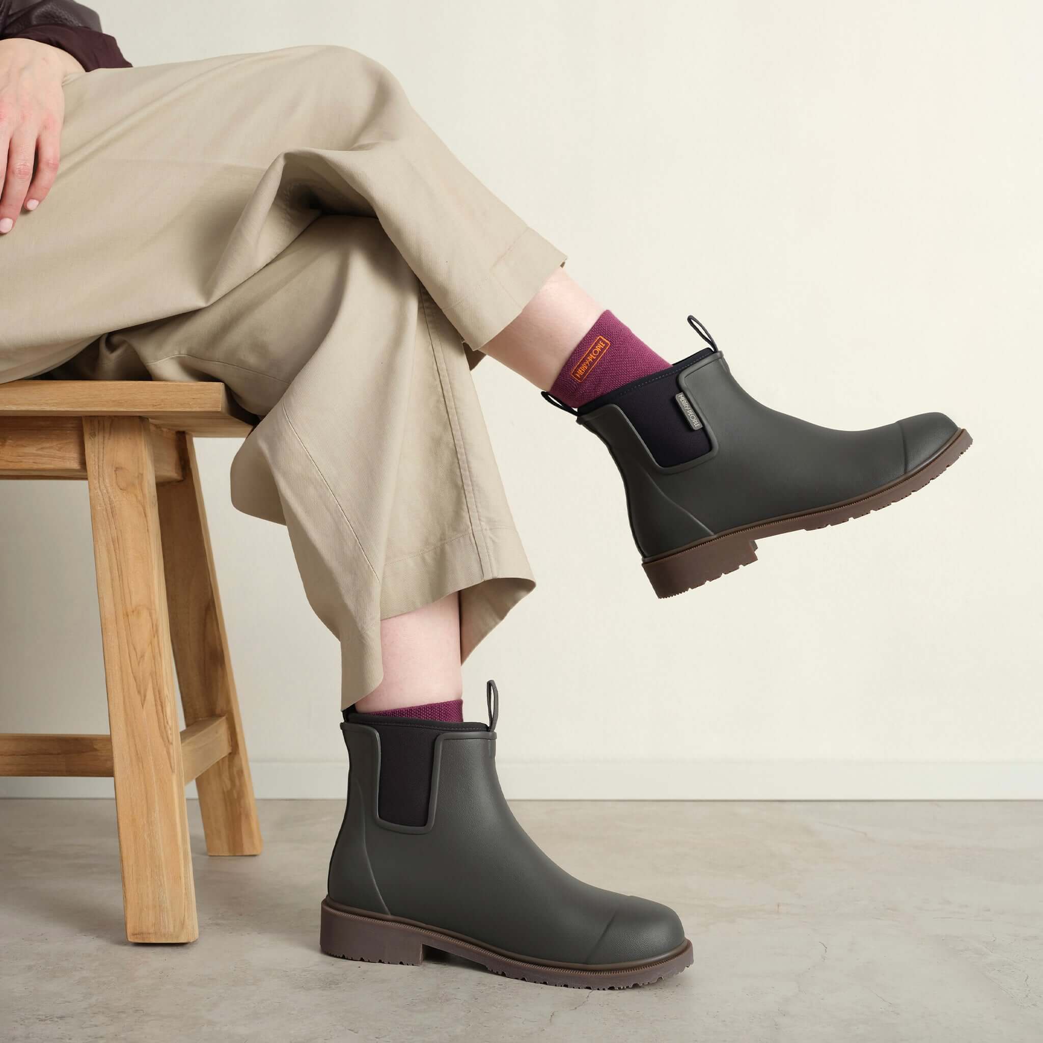 Merry People Bobbi Ankle Boots - Charcoal showcased on a person sitting, highlighting style and comfort.