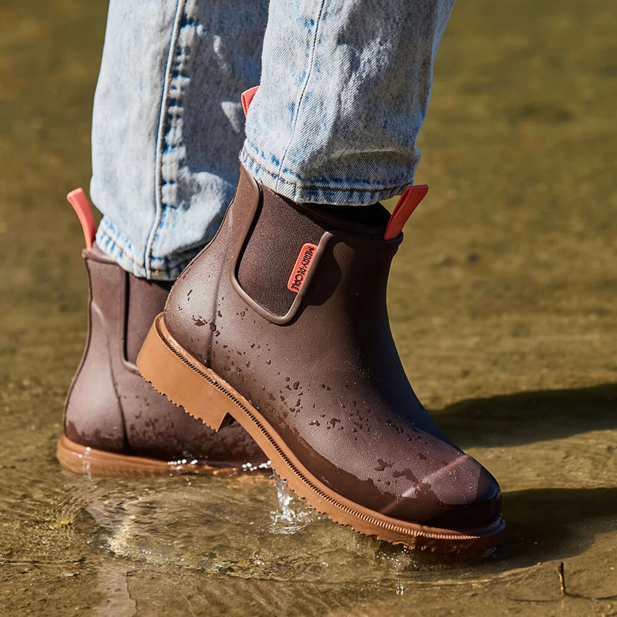 Merry People Bobbi Ankle Boots - Mocha being worn in water, showcasing waterproof design and flexible neoprene lining.