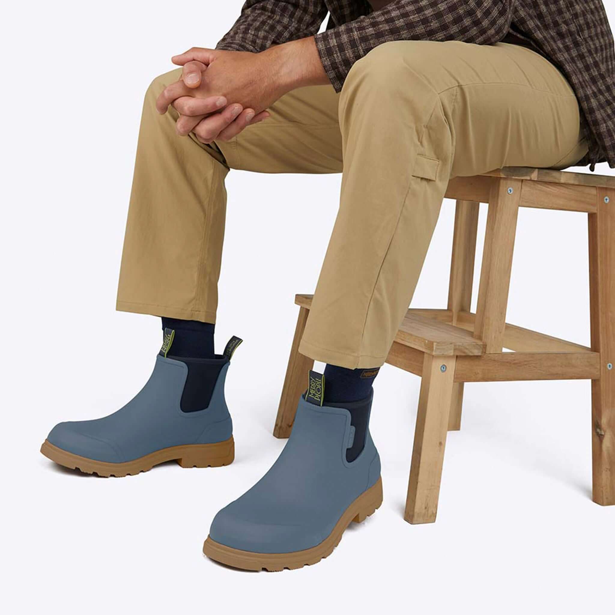 Alt Tag: Merry People Oberon Boots - Storm Blue unisex wide-fit waterproof rubber Chelsea boots with tan sole worn seated