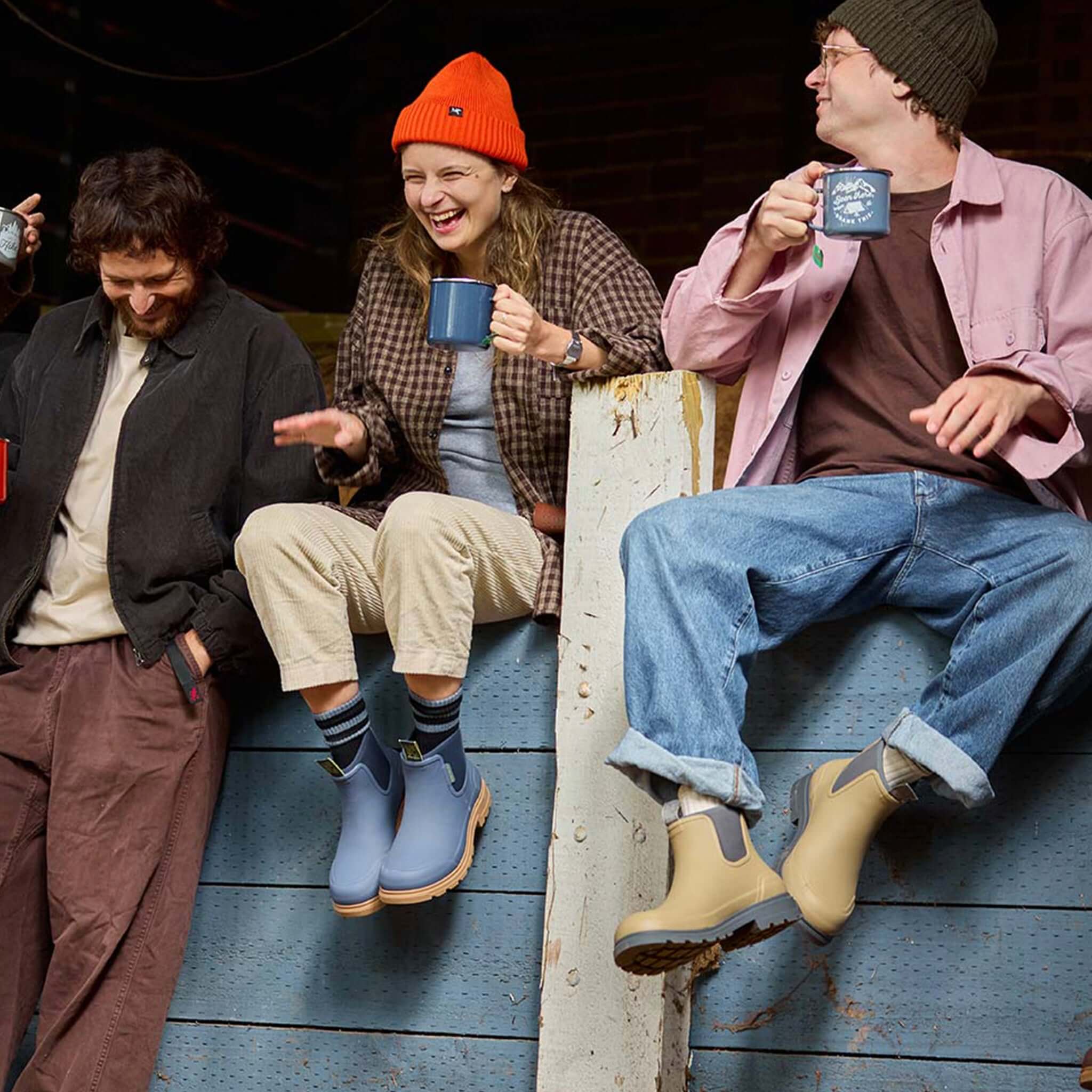 Alt Tag: Merry People Oberon Boots - Storm Blue worn by friends relaxing with mugs outdoors, waterproof wide-fit rubber boots for everyday adventures