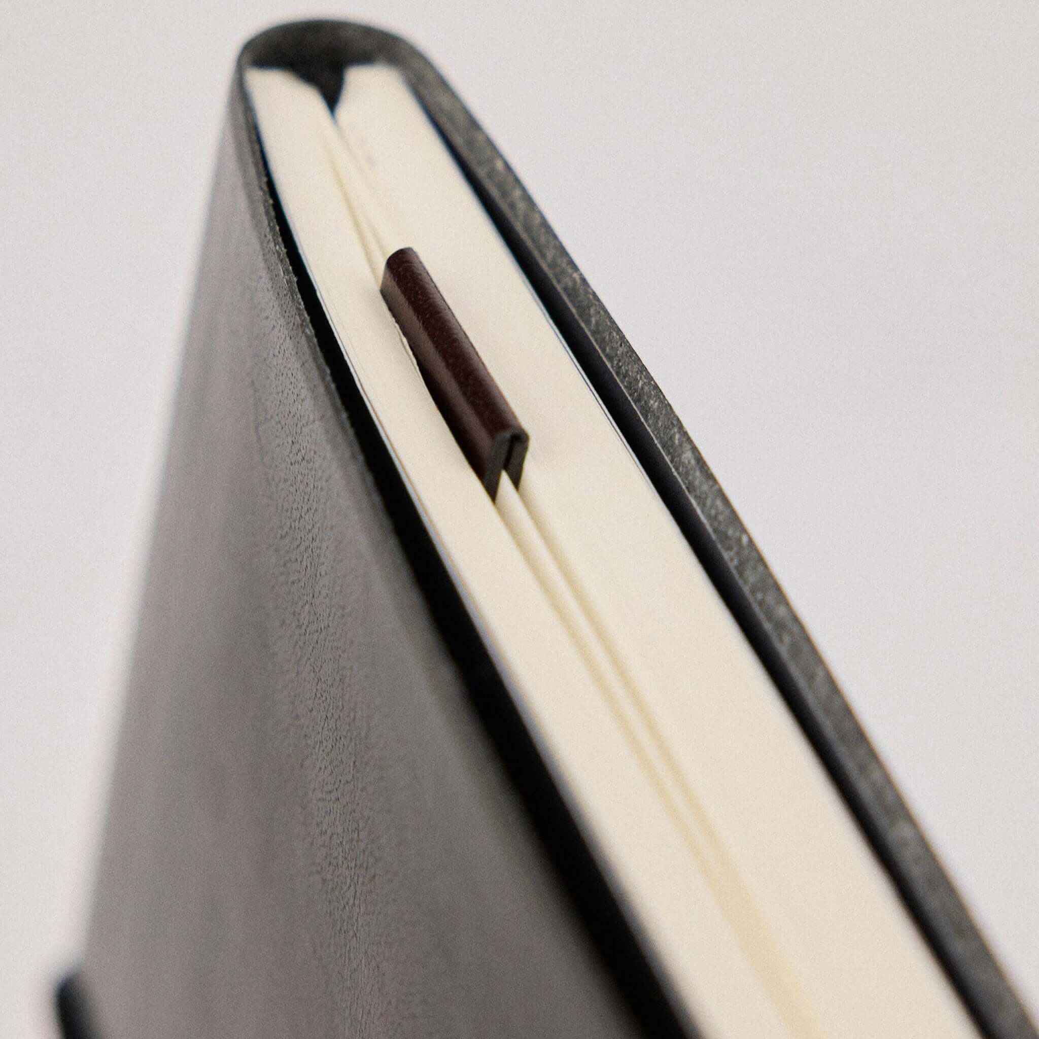 Milligram Recycled Leather Magnetic Page Markers - Burgundy placed on a notebook page.