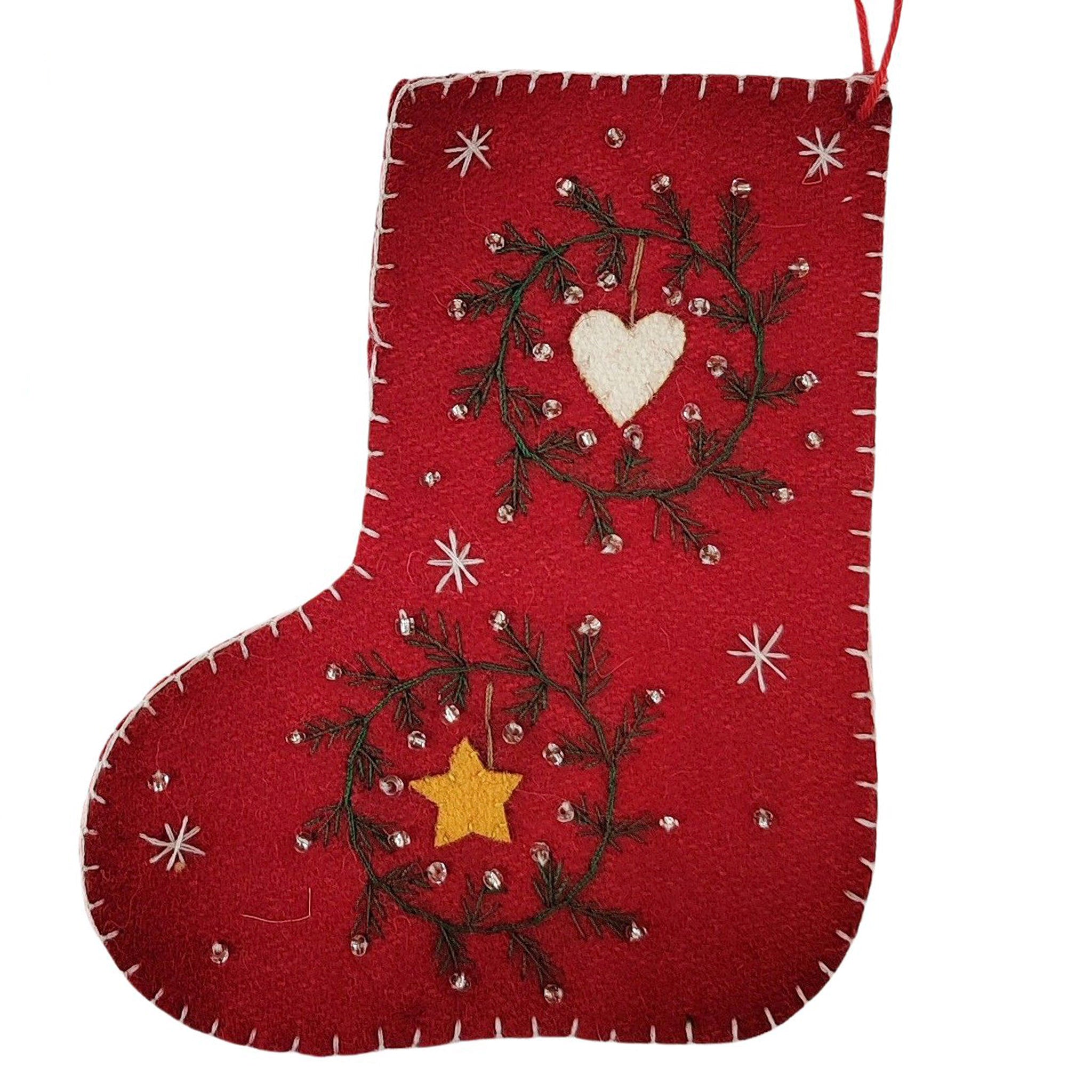 Red Christmas stocking with embroidered designs on a white background