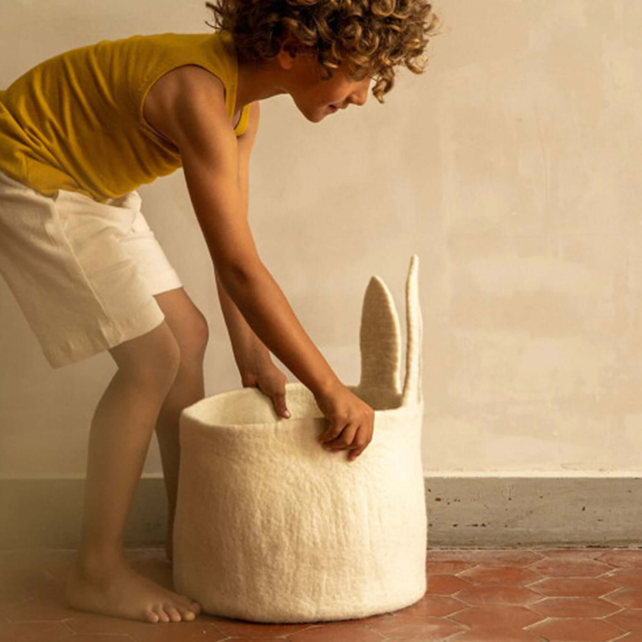 Muskhane Felt Basket - Pasu Bunny Natural being used by a child, showcasing its playful rabbit ears and practical design.