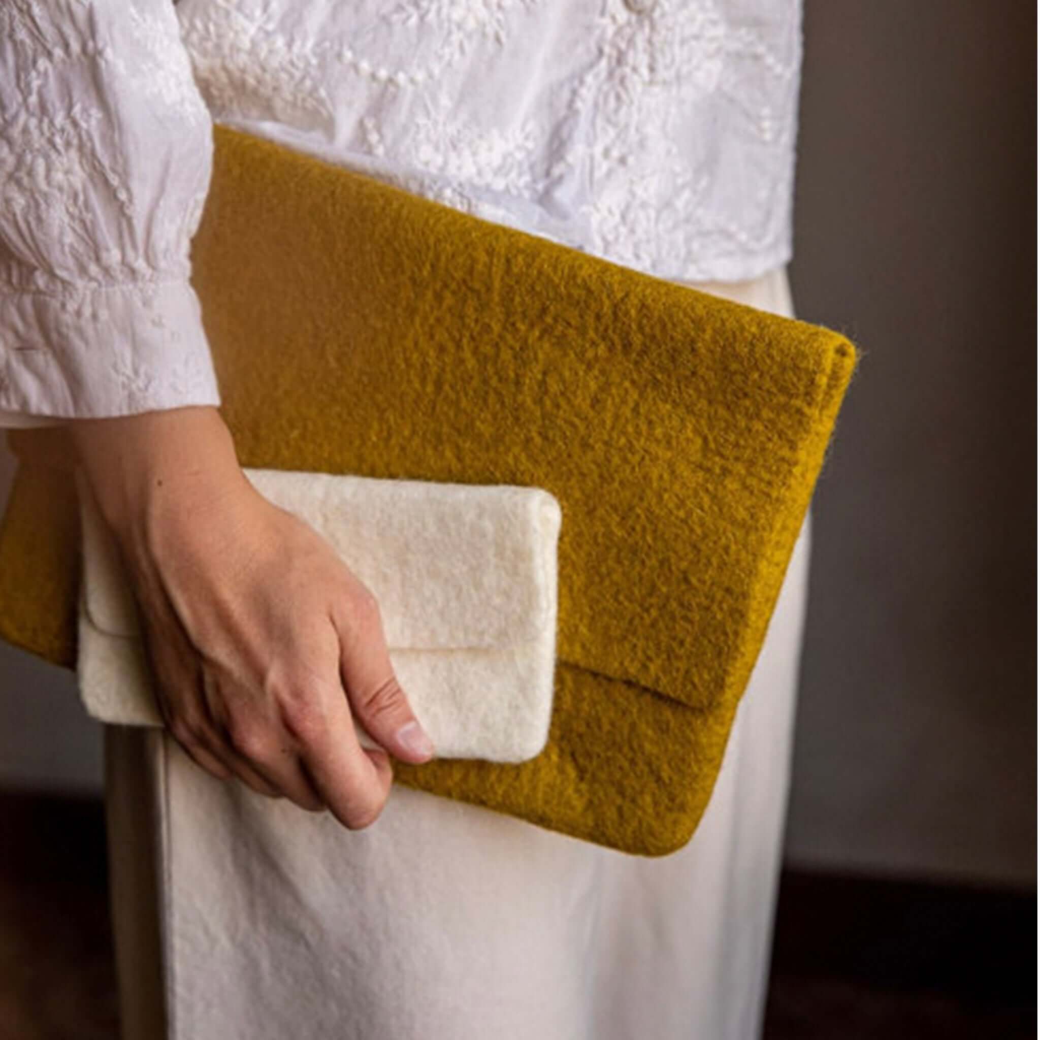 Muskhane Felt Glasses Case - Natural held by a person wearing a white top, showcasing its woollen felt design.
