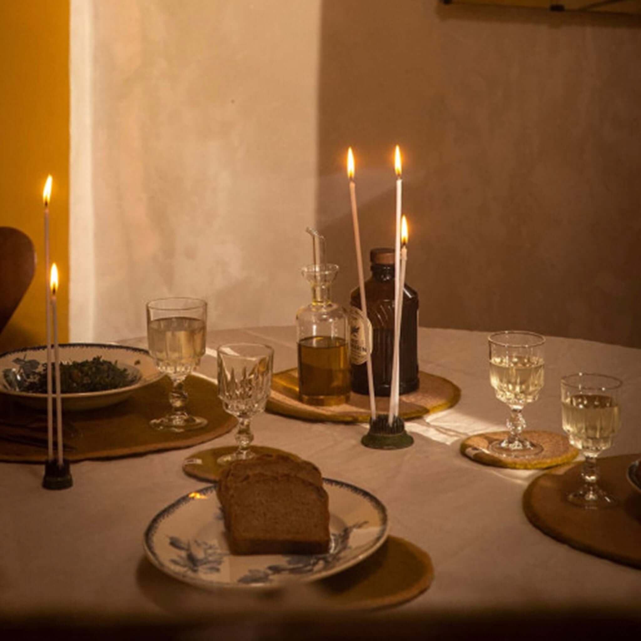 Muskhane Felt Two Tone Round Coaster -  Pistachio & Nude used on a dining table setting with candles and drinks.