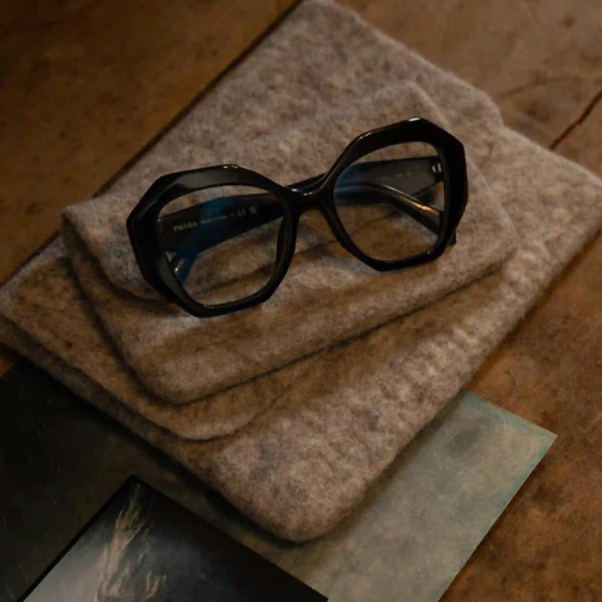 Black glasses on a textured surface with a blurred background