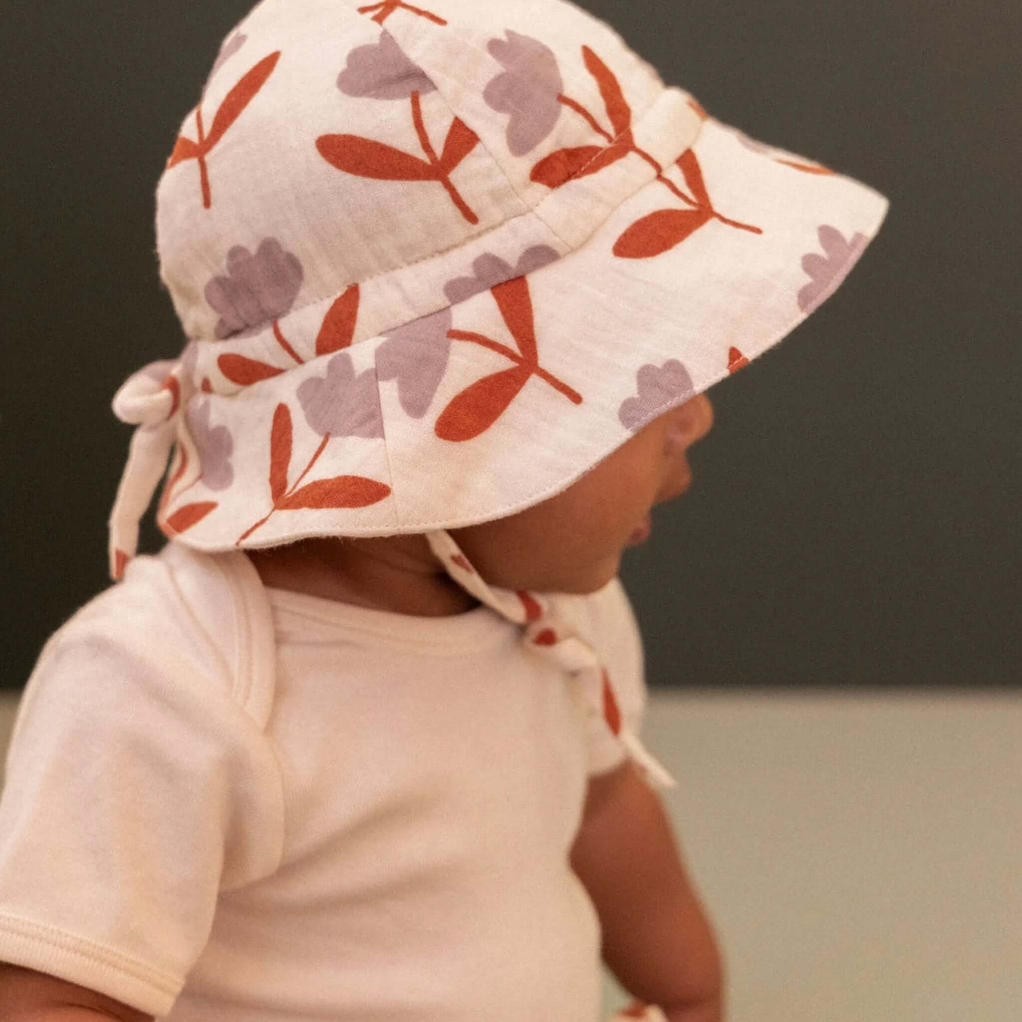 Nature Baby Muslin Sunhat - Fleurette on a baby, offering sun protection and style for little explorers.