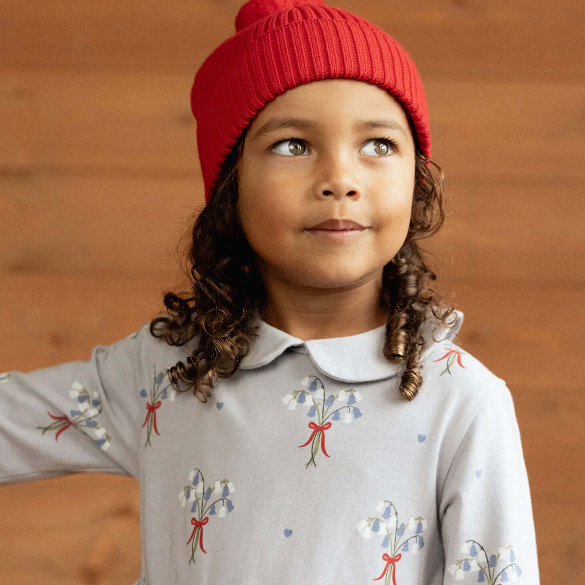 Alt Tag: Nature Baby Organic Cotton Forest Beanie - Red on child, chunky ribbed organic cotton fisherman beanie, cosy knitwear
