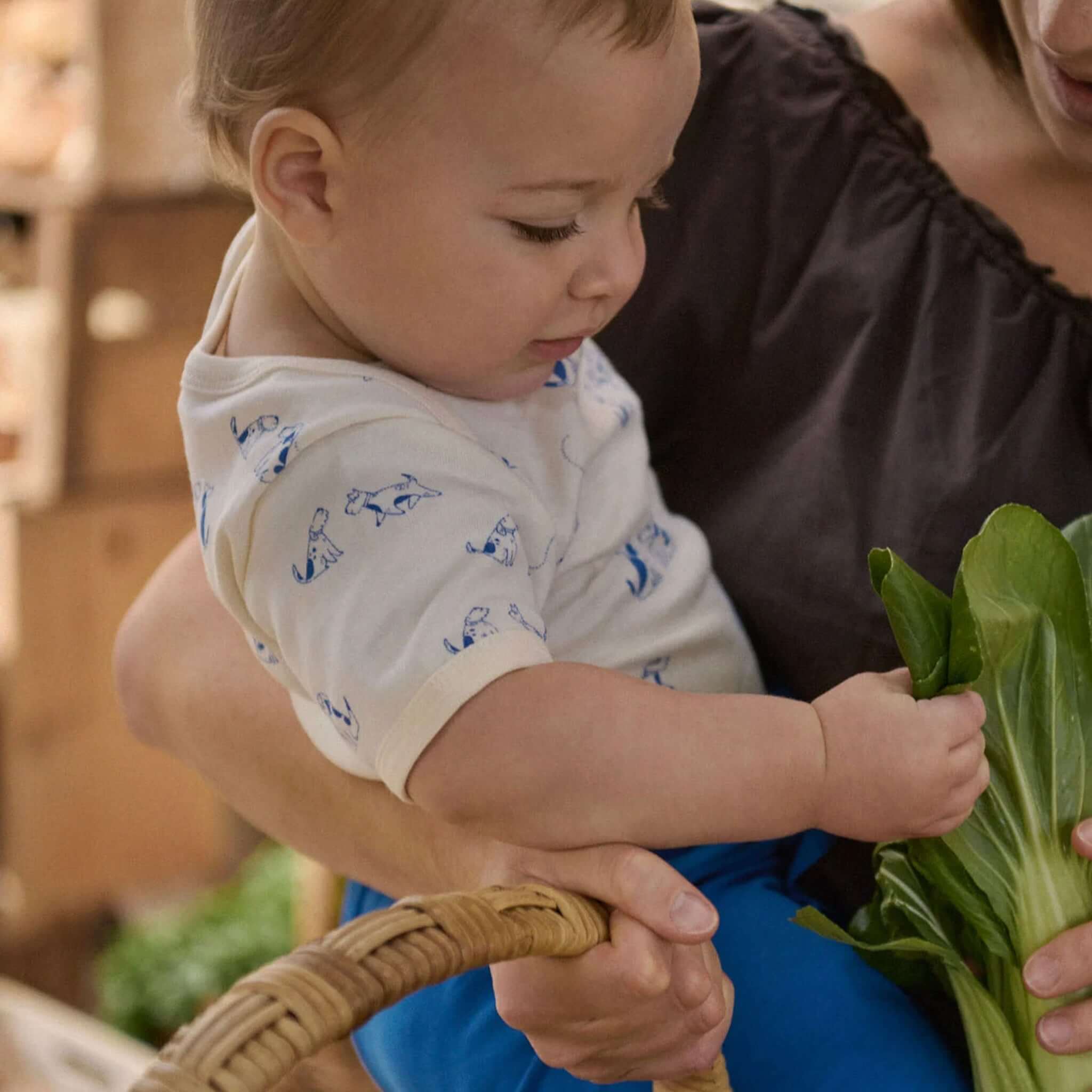 Nature Baby Organic Cotton Short Sleeve Bodysuit - Dog Walk, baby exploring vegetables, cozy organic cotton outfit.