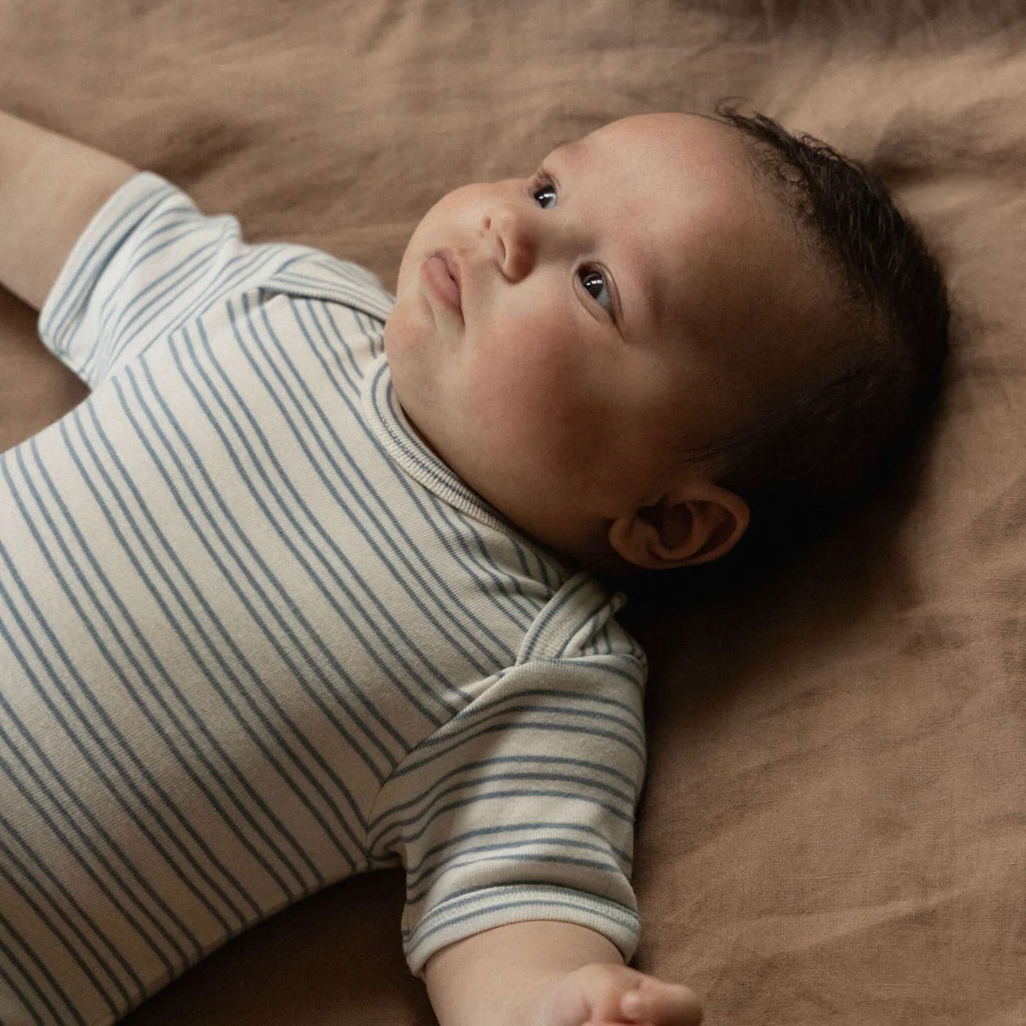 Nature Baby Organic Cotton Short Sleeve Bodysuit - Stripe Trio on a baby, showcasing comfort and style.