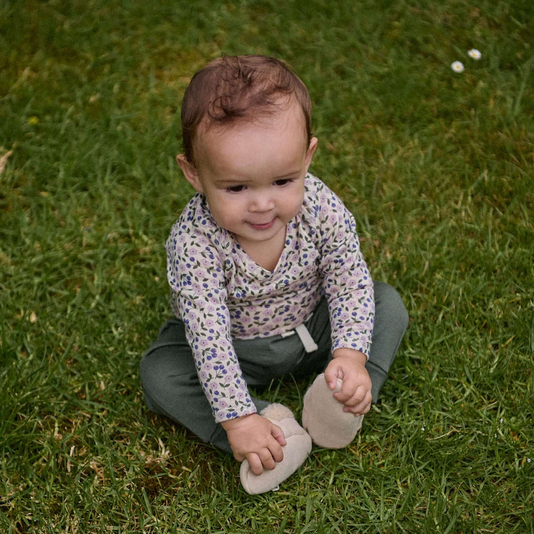 Alt Tag: Nature Baby Organic Merino Wool Drawstring Pants - Thyme on baby sitting on grass, soft elastic waist and drawstring fit