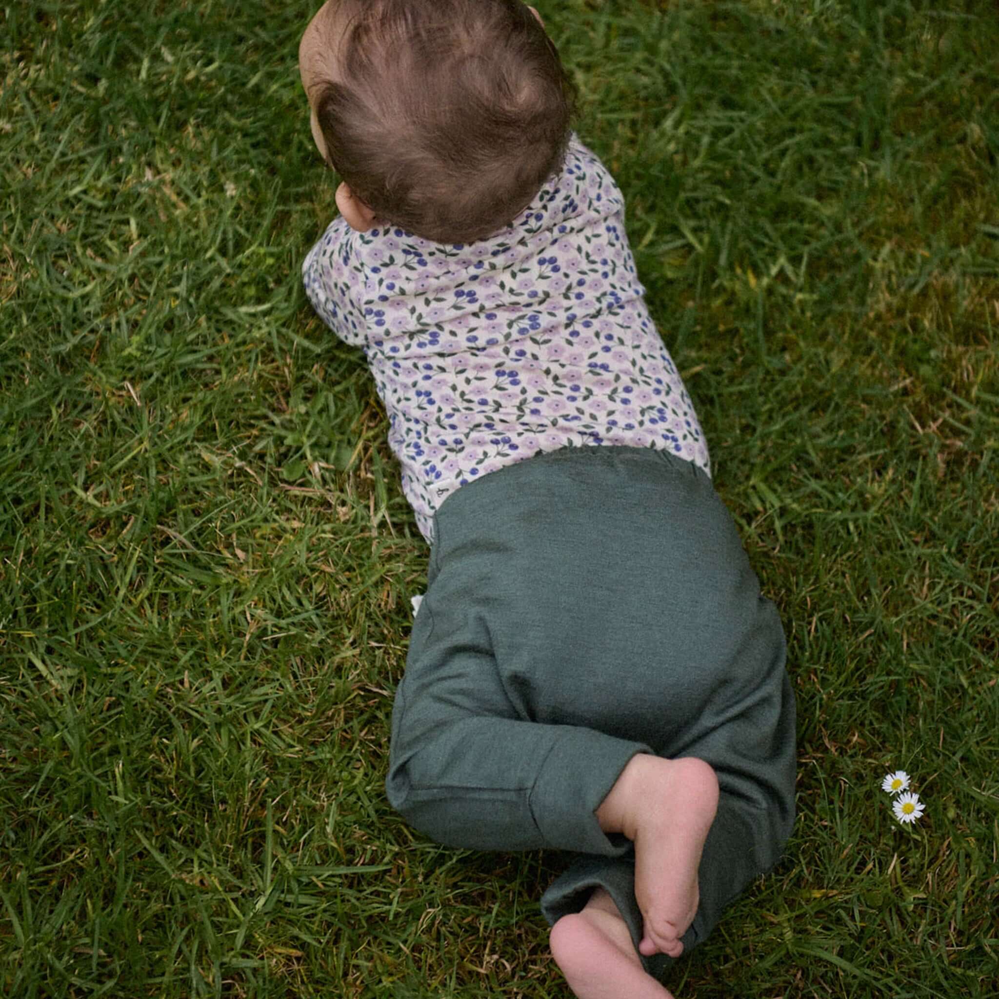 Alt Tag: Nature Baby Organic Merino Wool Drawstring Pants - Thyme on baby crawling on grass, soft cuffed tapered leg everyday merino pants