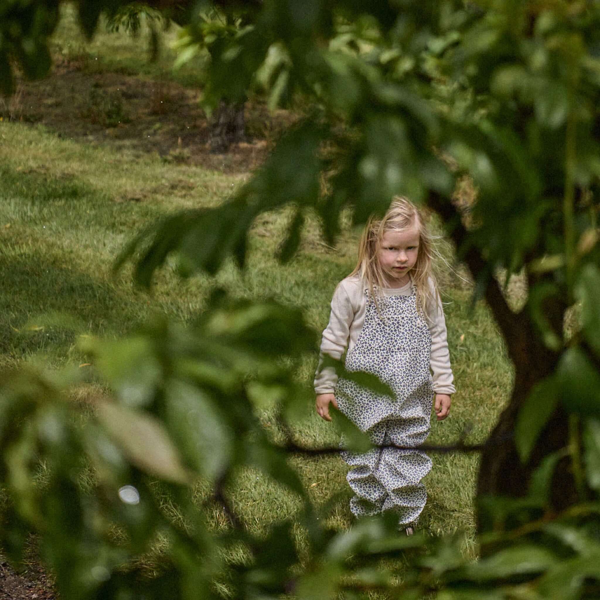 Alt Tag: Nature Baby Splash Overalls - Briarwood Heron on toddler outdoors in garden, waterproof splash overalls for wet weather play