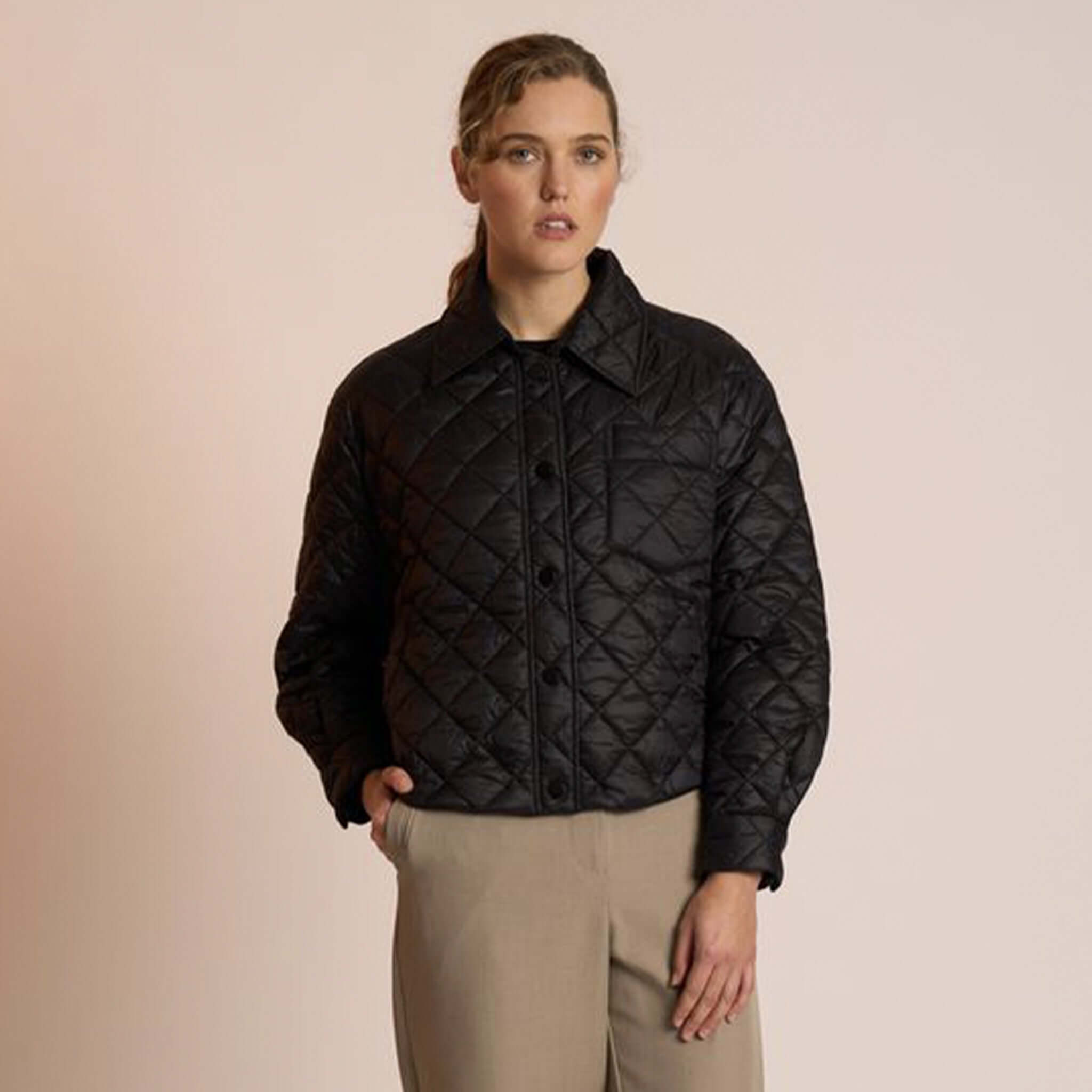 Alt Tag: Neris Gia Jacket - Jett quilted cropped jacket with structured collar and snap domes, worn by model in studio