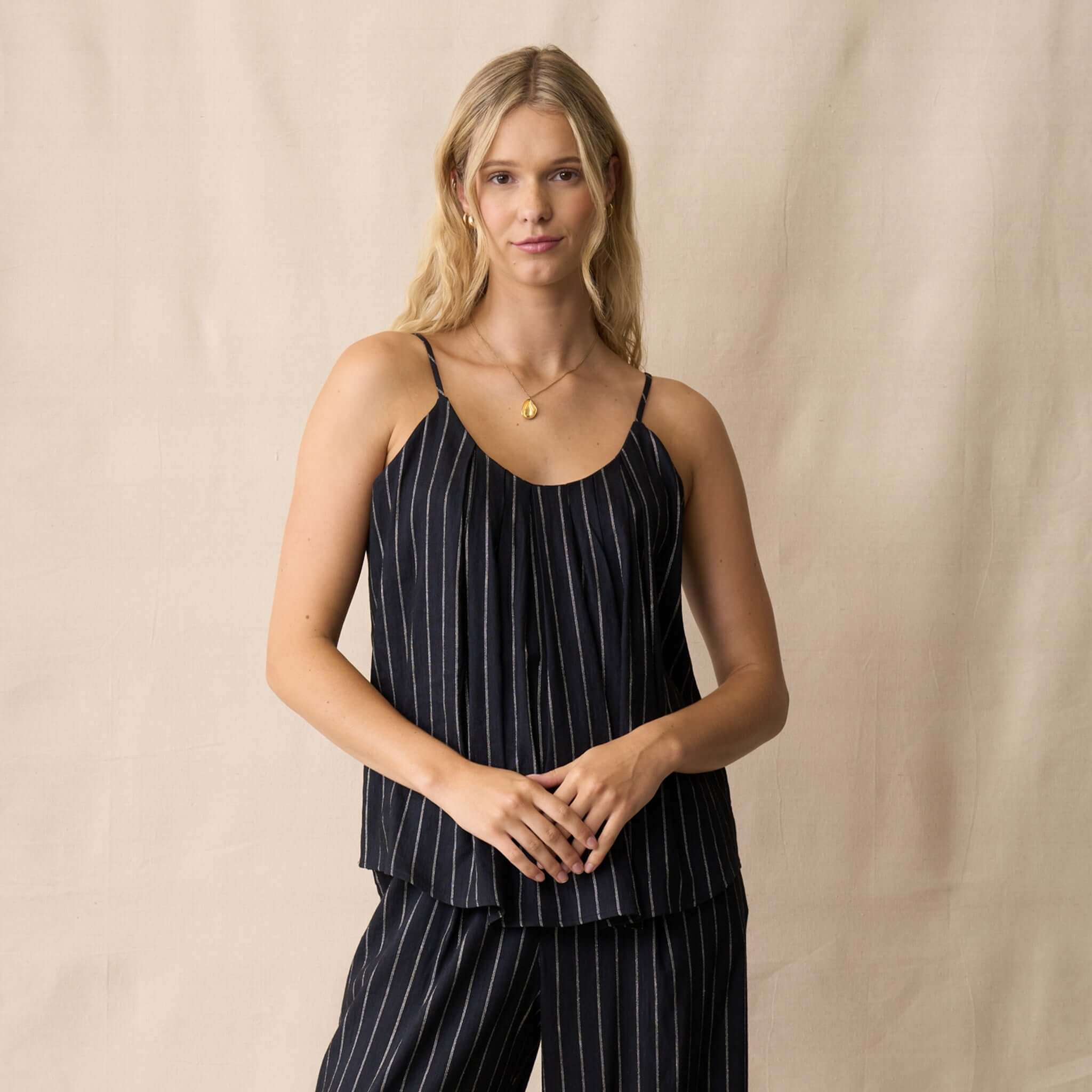 Model wearing Neris Sloane Cami - Midnight, a flowing cami with vertical stripes and adjustable straps.