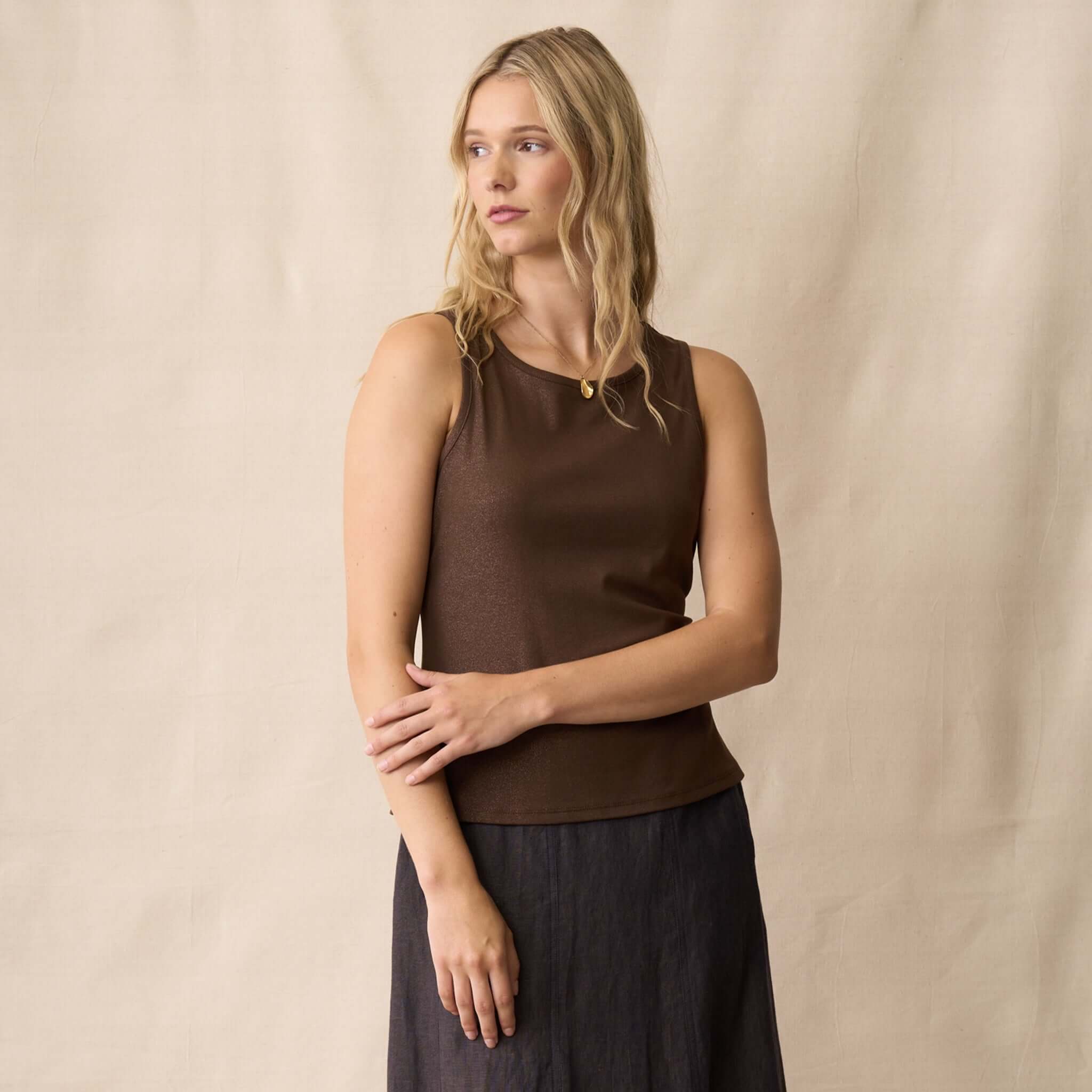 Model wearing Neris Ziggy Tank - Copper against a neutral background, showcasing its sleek design and shimmer.