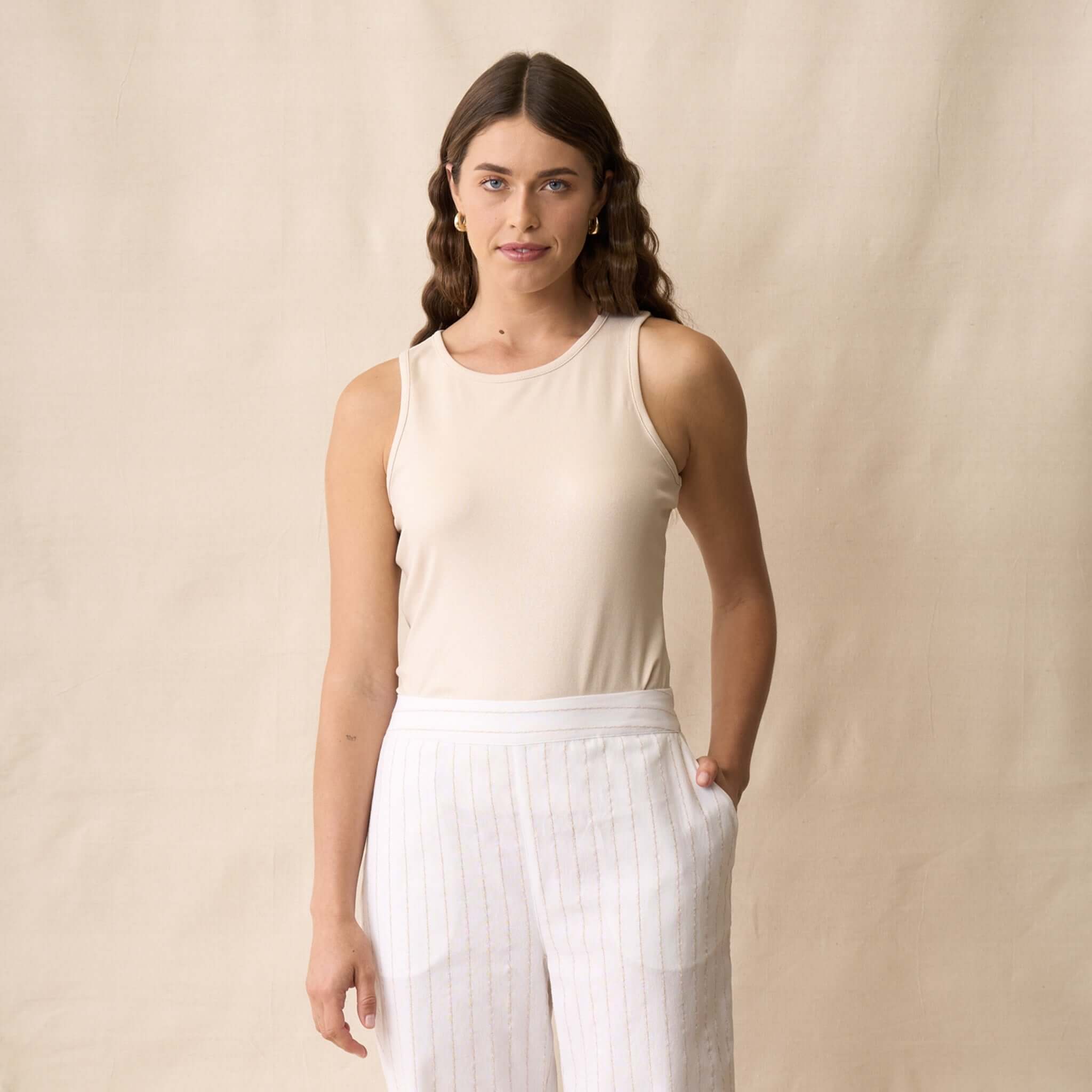 Model wearing the Neris Ziggy Tank - Sand with clean lines and subtle shimmer, perfect for day to night outfits.