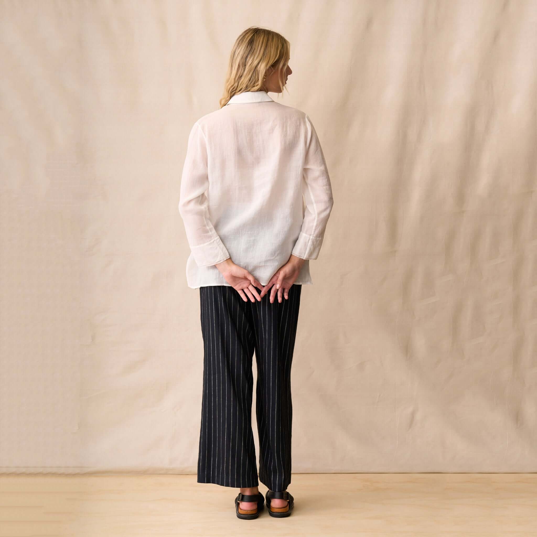 Model wearing the Neris Drew Shirt - White from the back, showcasing its sheer design and classic collar.