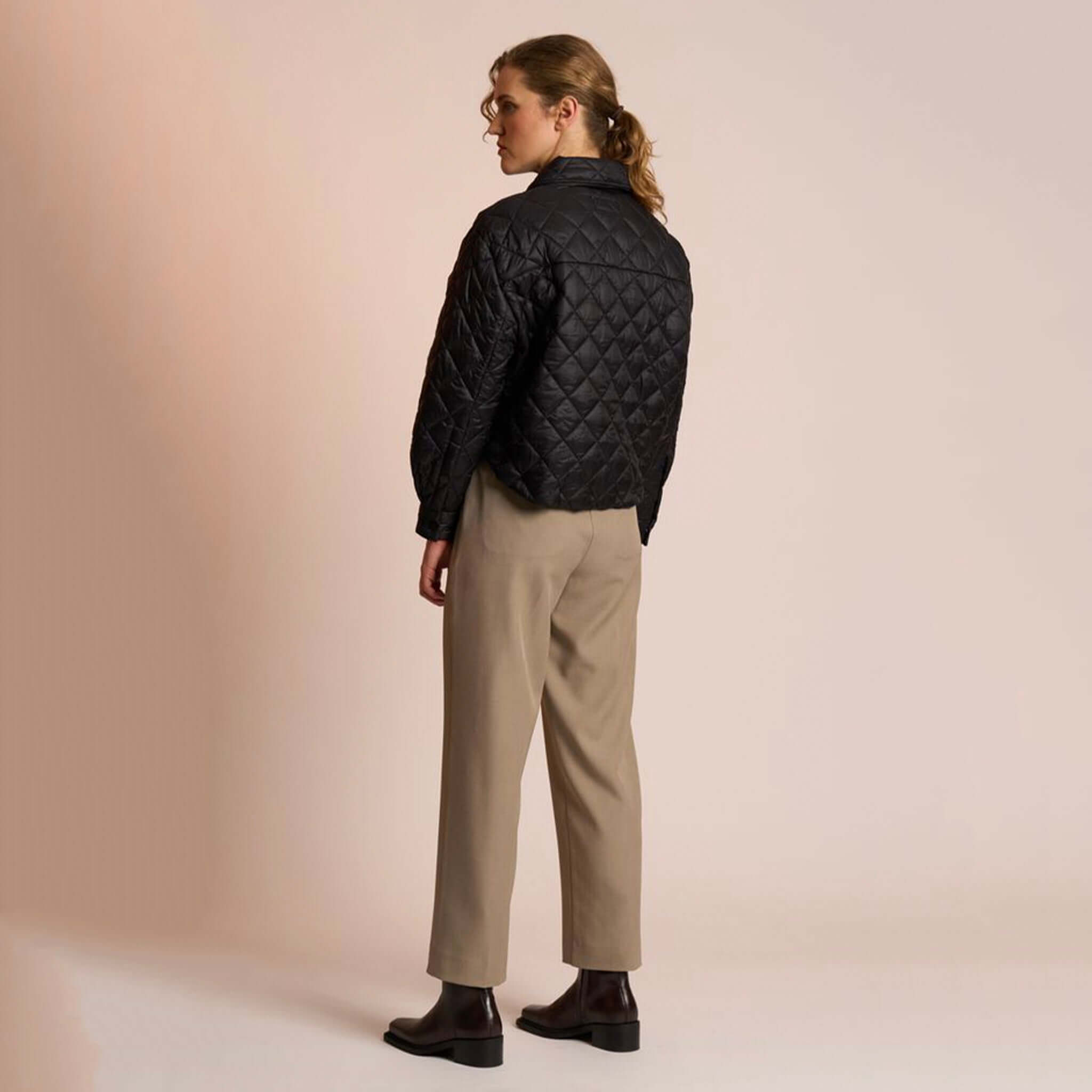 Neris Gia Jacket - Jett black quilted cropped jacket on model, back view with snap domes and structured collar