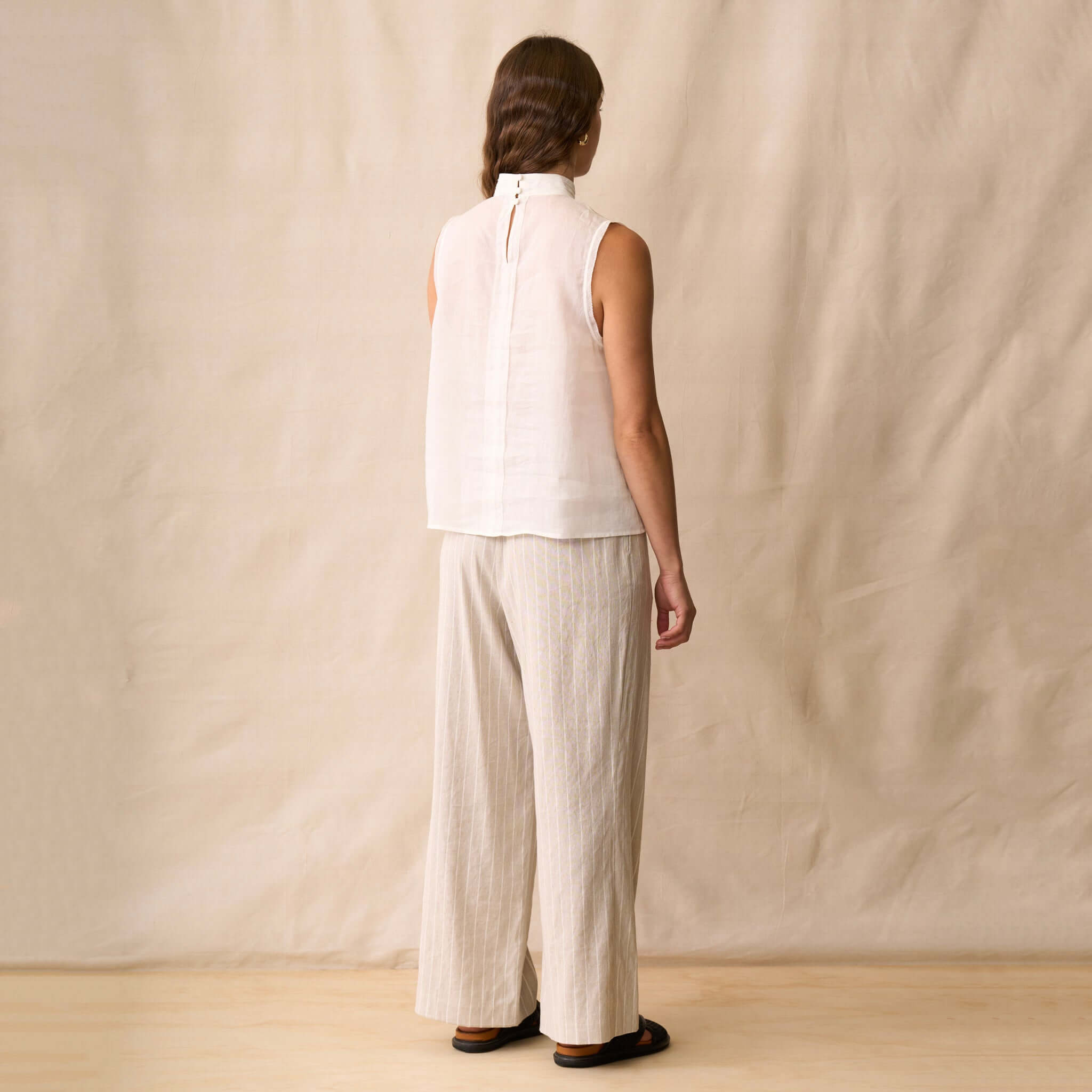 Neris Phoebe Top - White shown from behind, featuring a sleeveless design and a pleated neckline.
