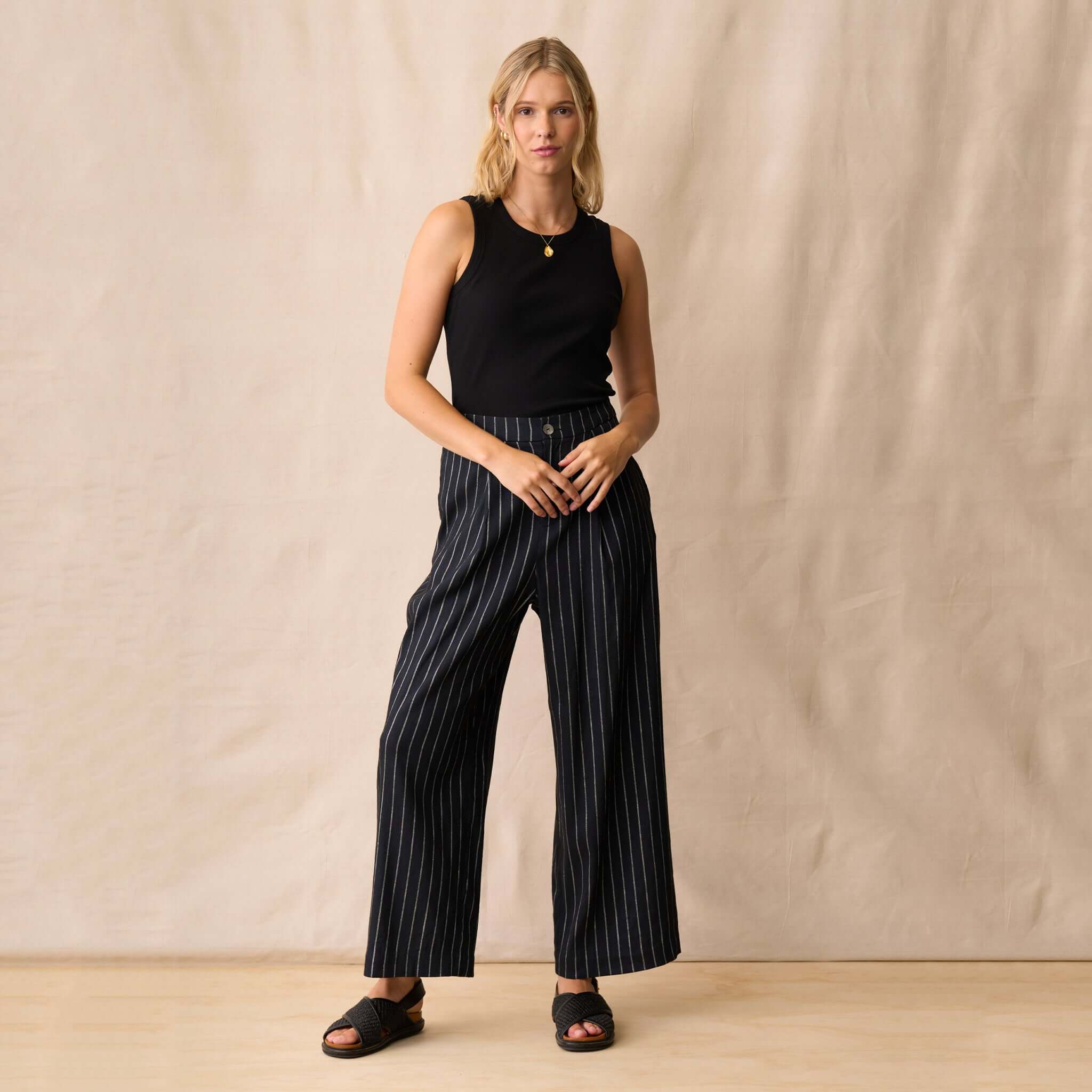 Neris Sloane Trouser - Midnight worn by a model, showcasing its relaxed tailoring and metallic pinstripe detail.