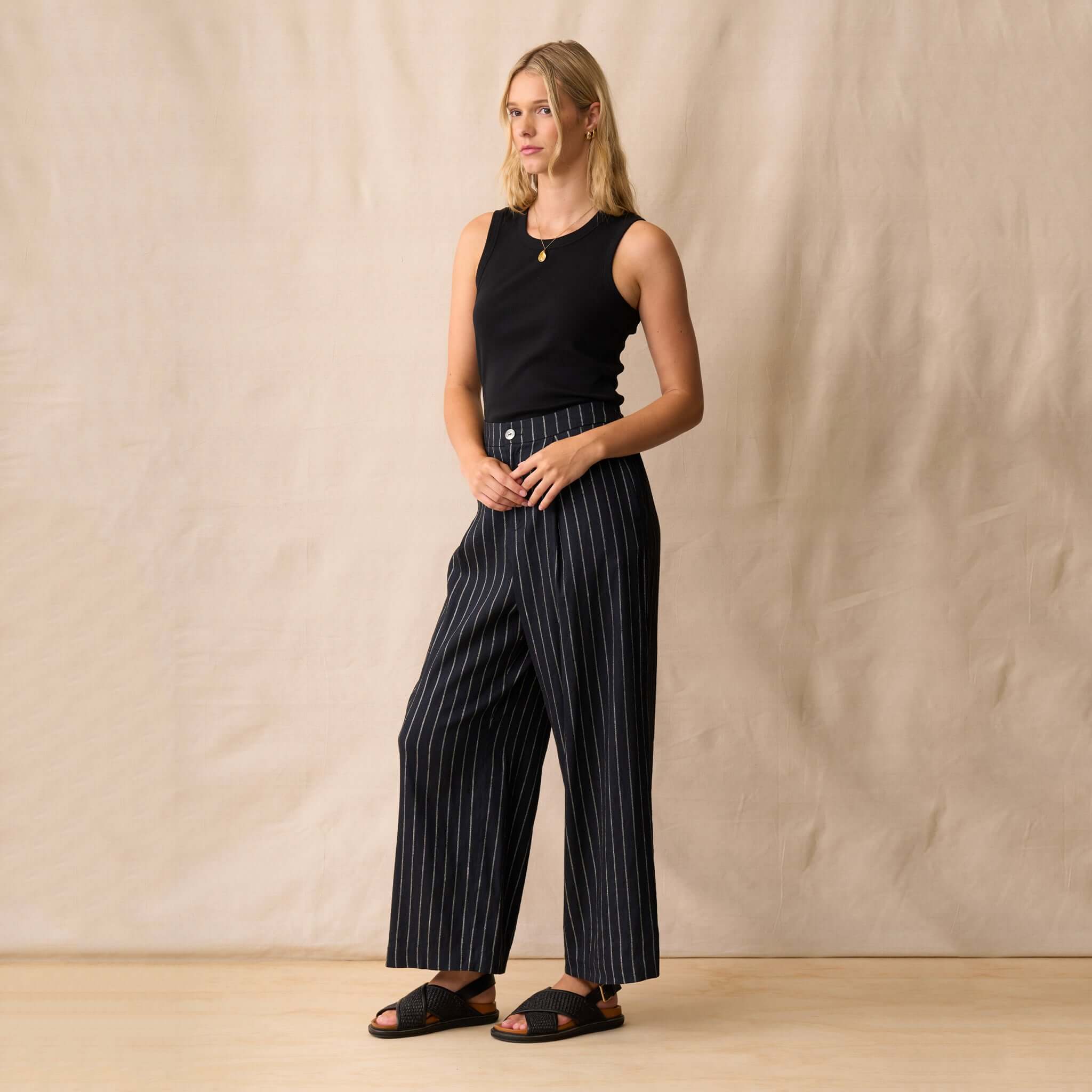 Neris Sloane Trouser - Midnight styled with a black tank top, featuring a straight-leg design and metallic pinstripes.