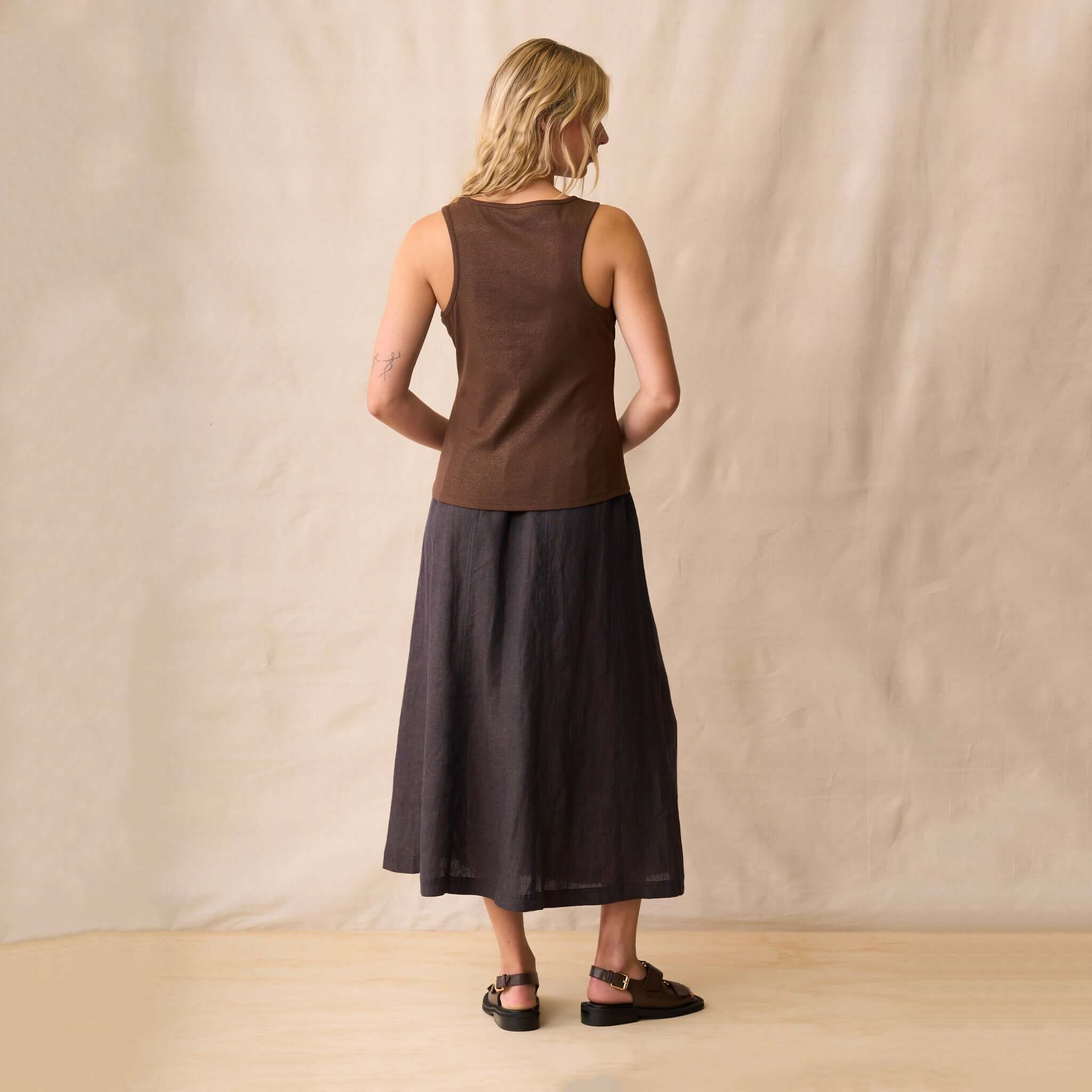 Neris Ziggy Tank - Copper showcased in a sleeveless style with a high neckline, worn elegantly with a skirt.