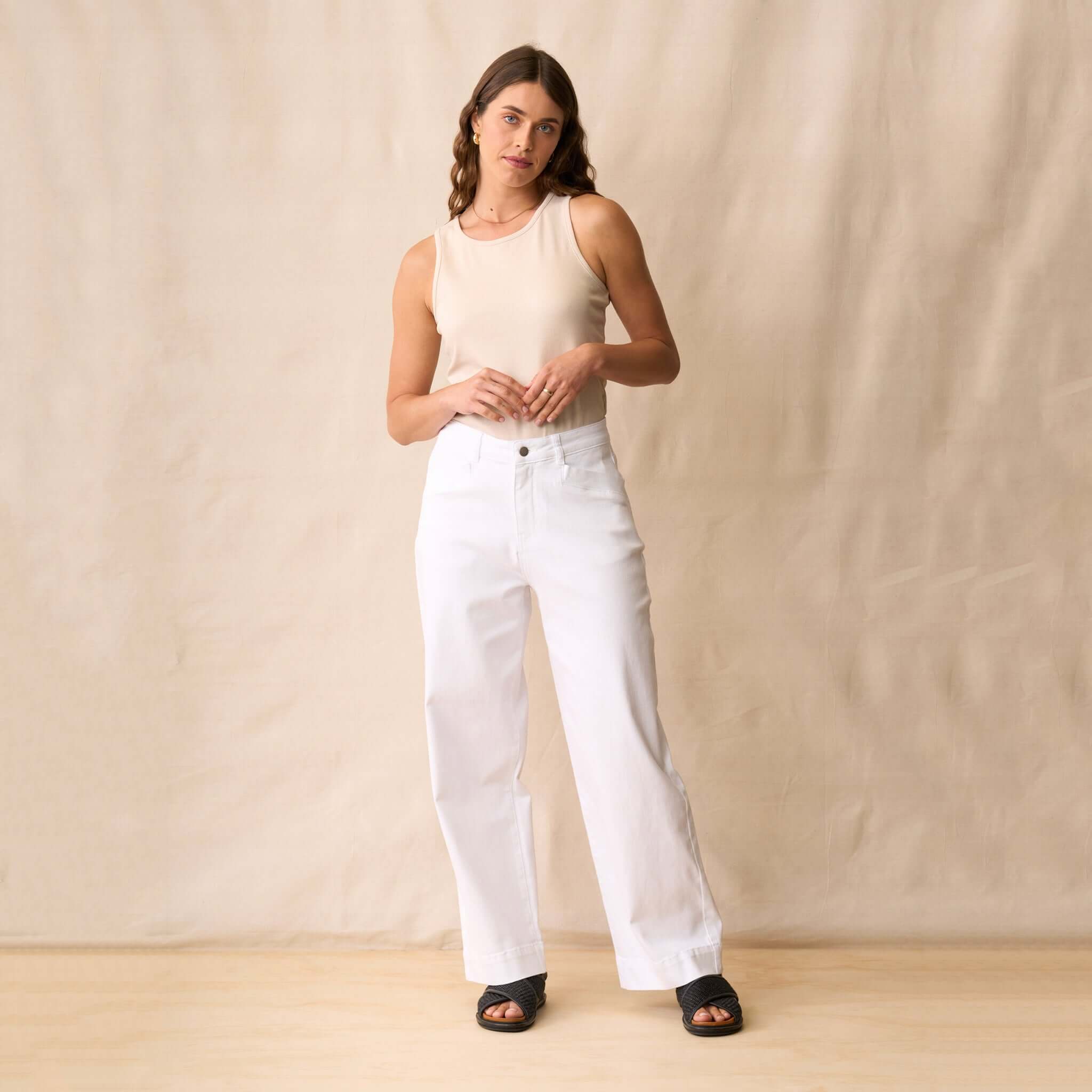 Neris Ziggy Tank - Sand worn with white wide-leg jeans on a model, showcasing its versatile day-to-night style.