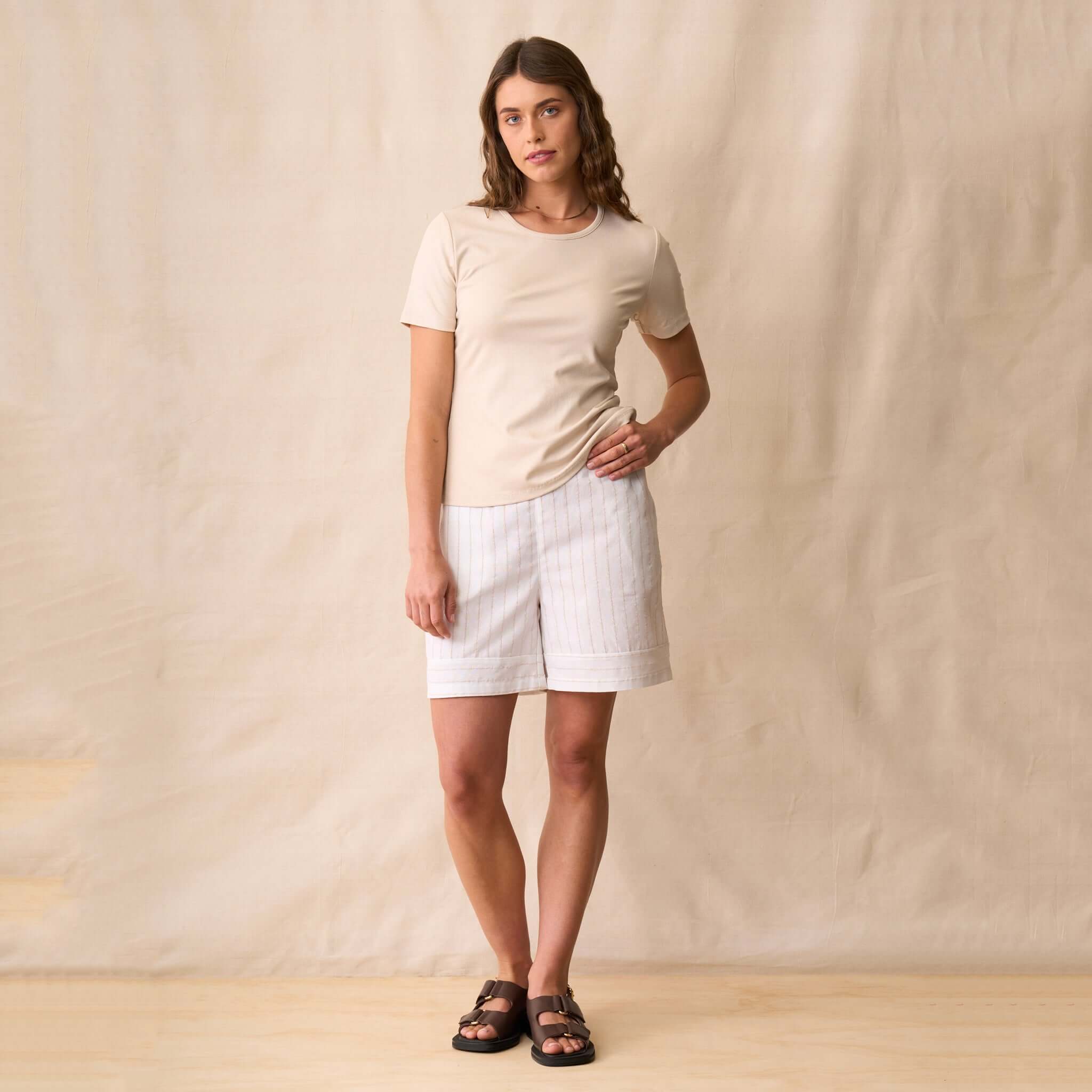 Neris Ziggy Tee - Sand worn with linen shorts, showcasing a soft cotton stretch fabric and a classic crew neckline.