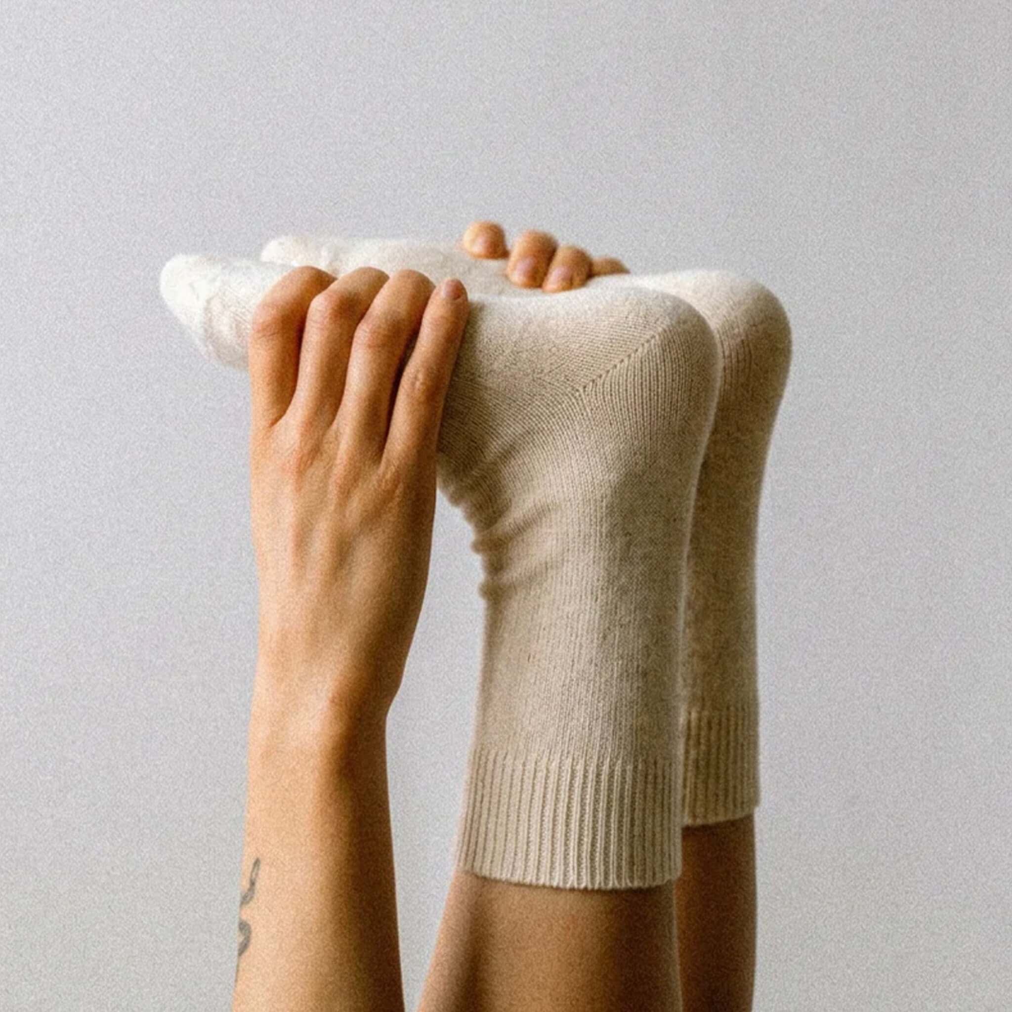 Nooan Hamilton Possum Merino Hamilton Socks - Marshmallow displayed on feet with hands holding them up.