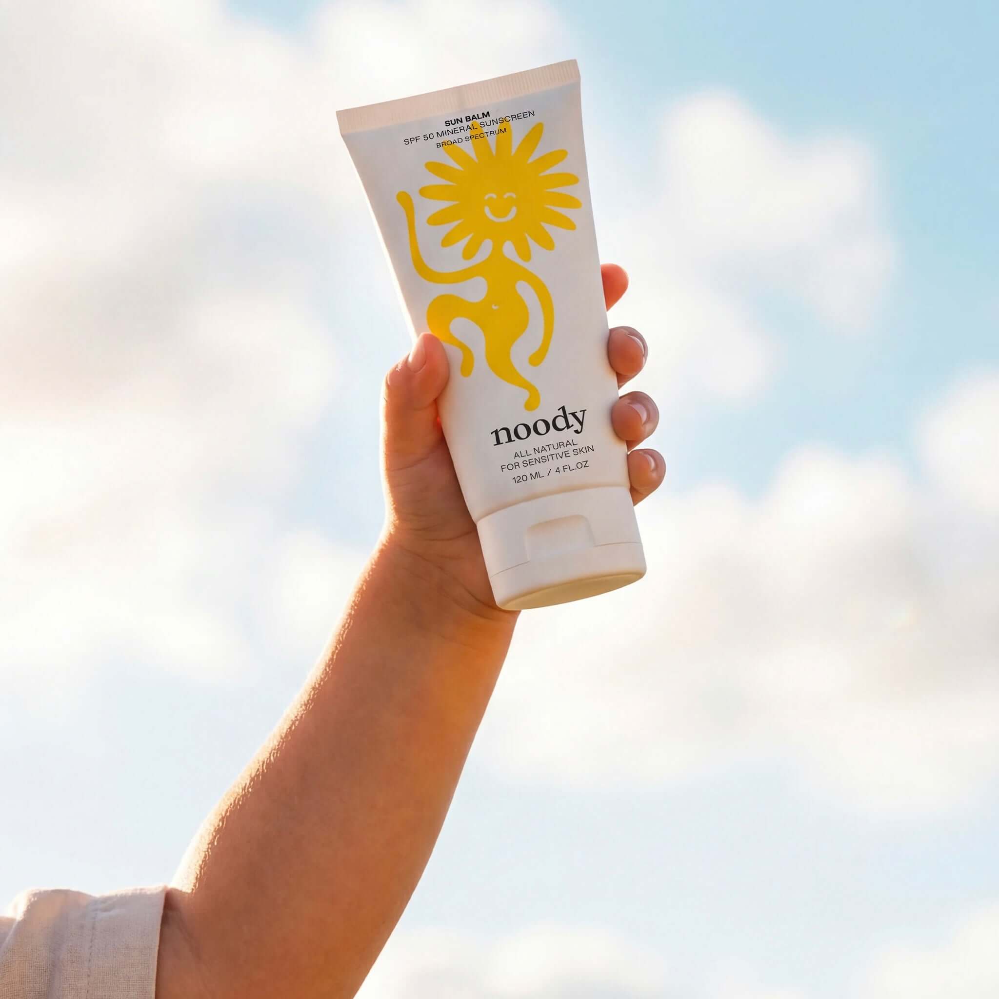 Alt Tag: Noody Sun Balm SPF 50 mineral sunscreen tube held up outdoors, gentle non-nano zinc oxide broad-spectrum UVA/UVB protection