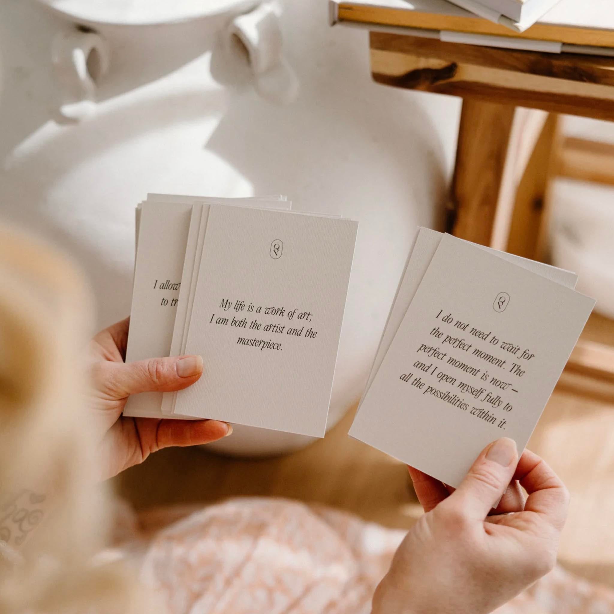 Two hands holding cards with text, blurred background