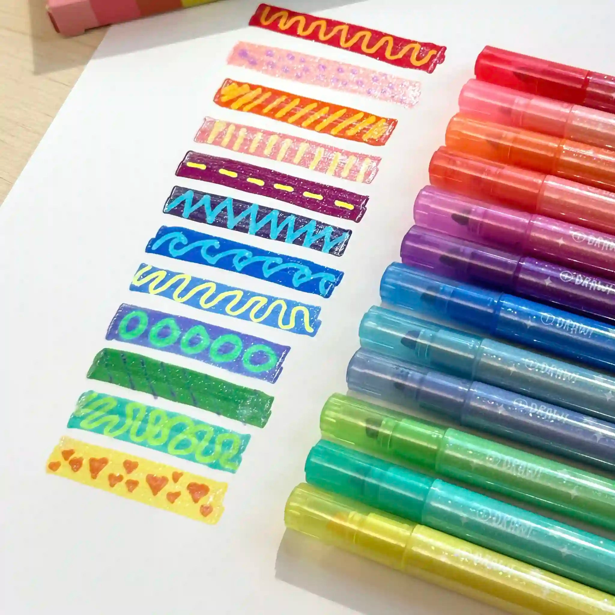 Set of colorful markers with sample designs on a paper background