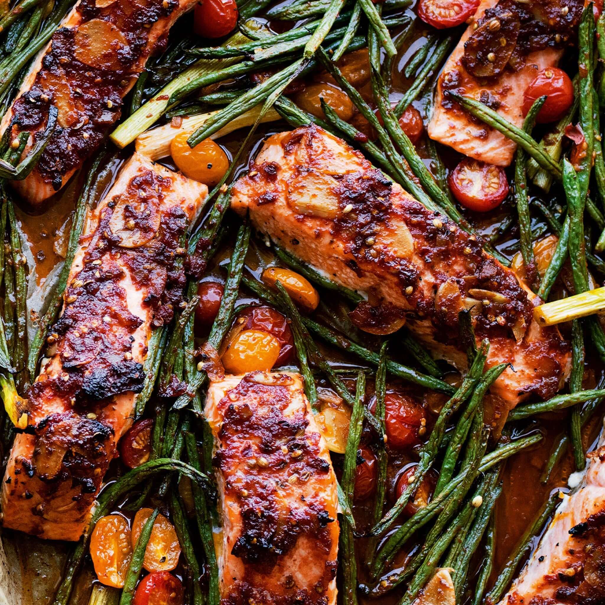 Alt Tag: Ottolenghi Comfort cookbook recipe featuring roasted salmon with green beans and cherry tomatoes in rich savory sauce