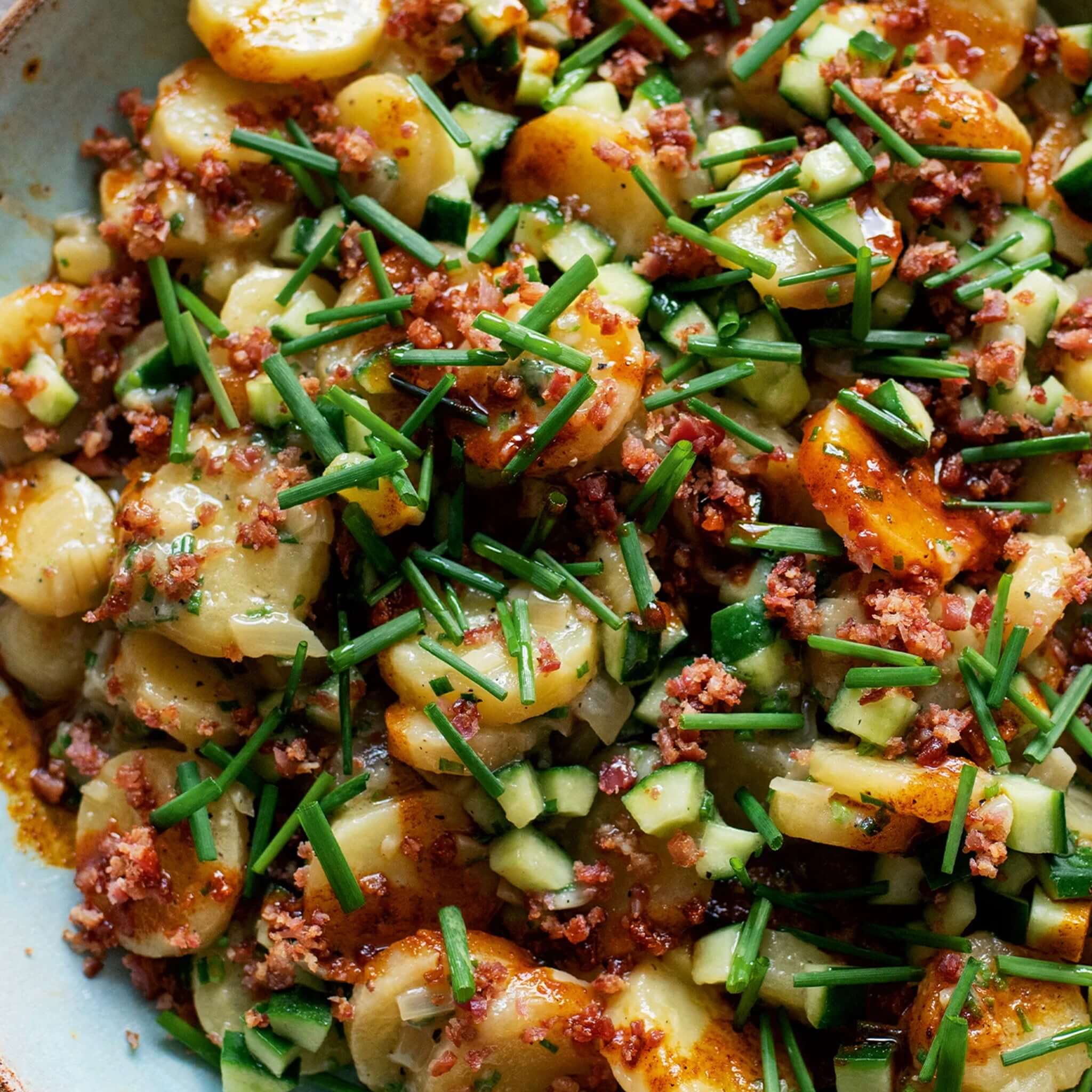 Alt Tag: Ottolenghi Comfort cookbook cover image featuring a comforting potato salad with chives, cucumber, and crispy bacon bits