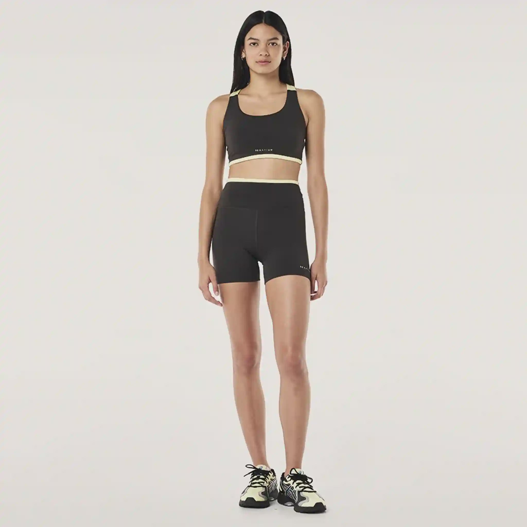 Woman wearing a black athletic outfit on a white background