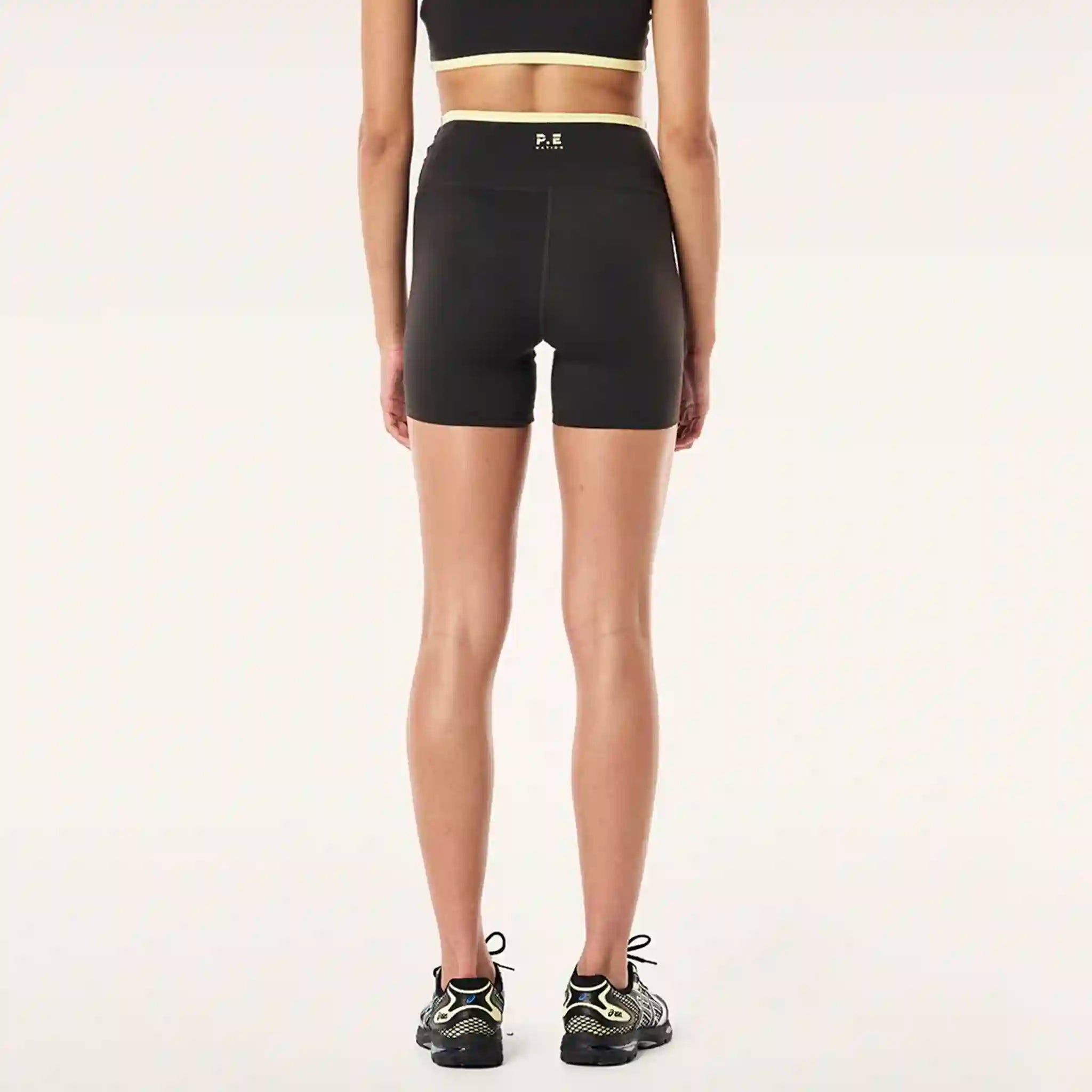 Person wearing black athletic shorts on a white background