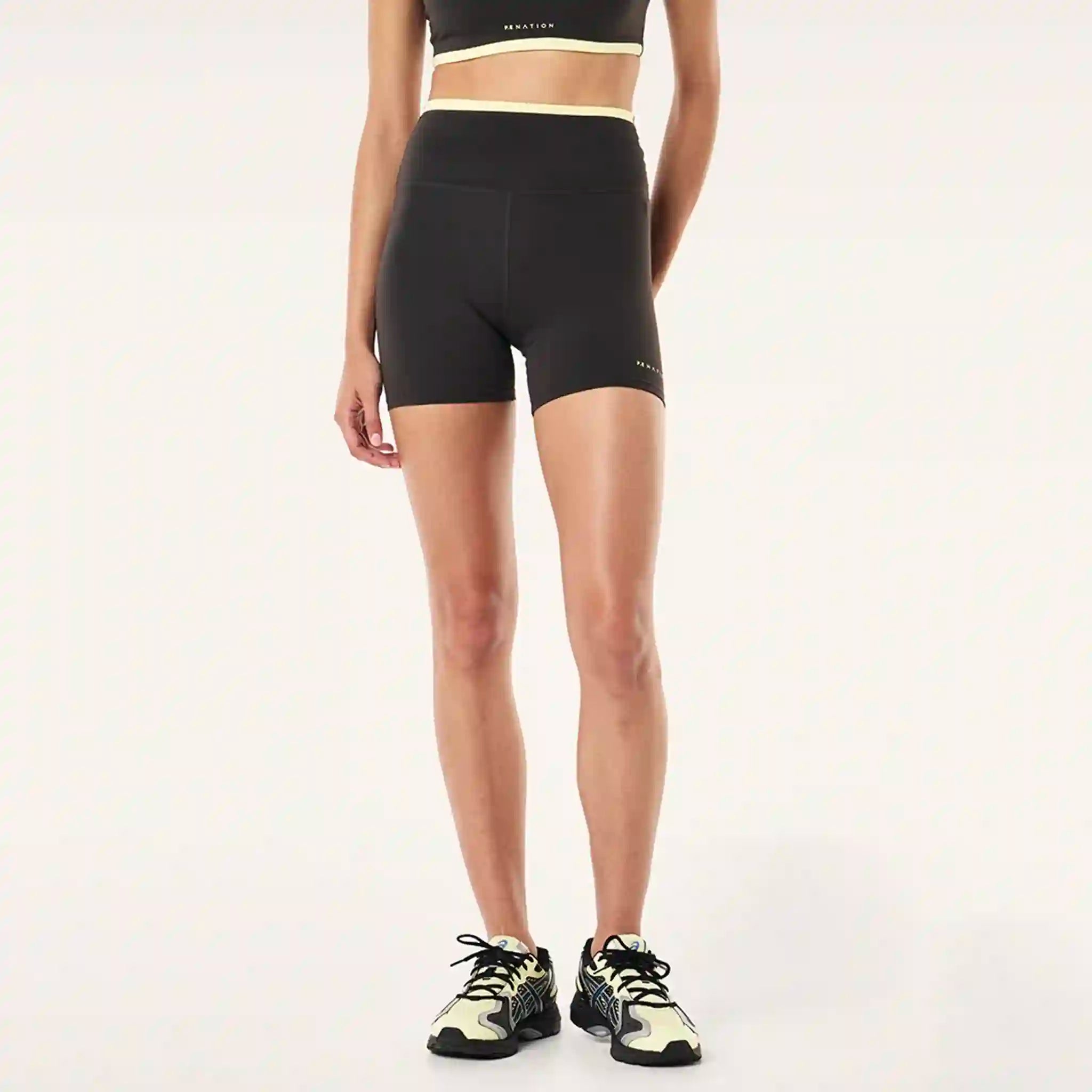Person wearing black athletic shorts on a white background