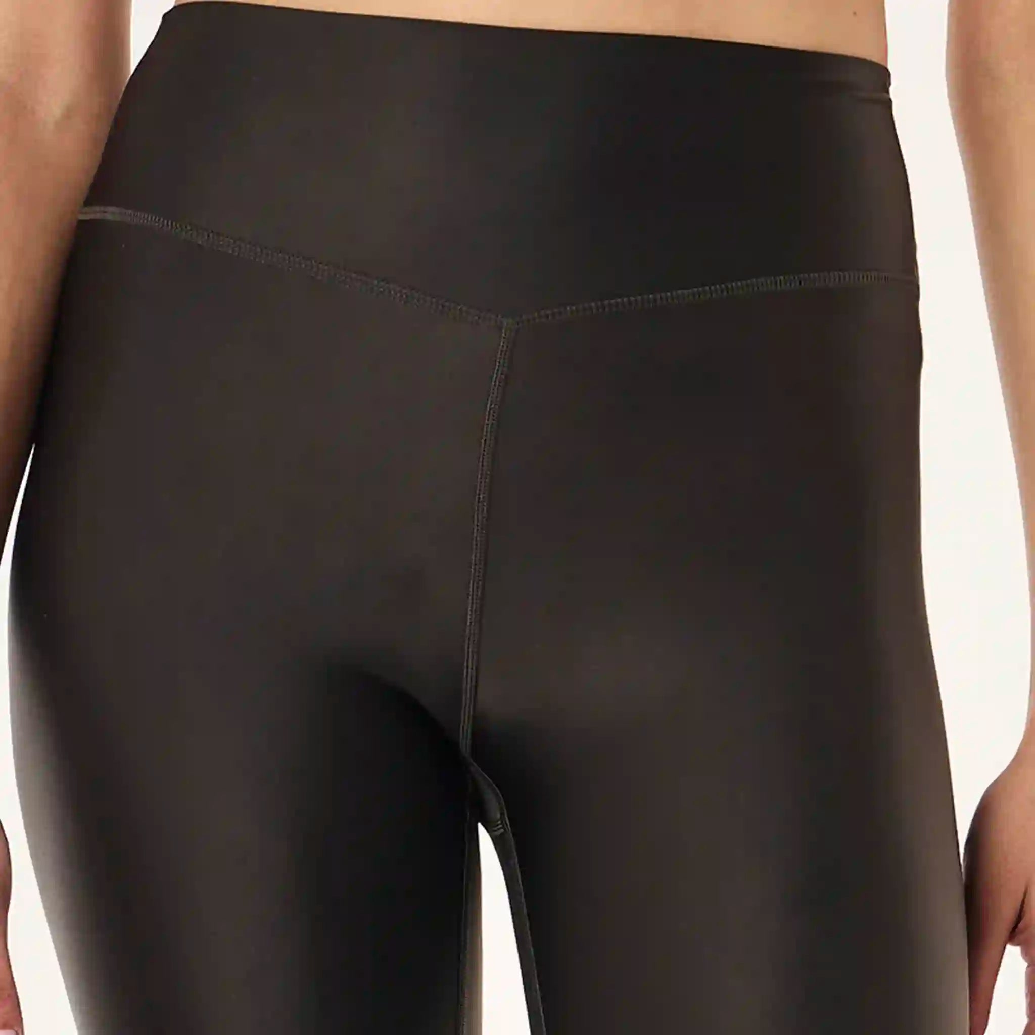 Close-up of black leggings on a neutral background