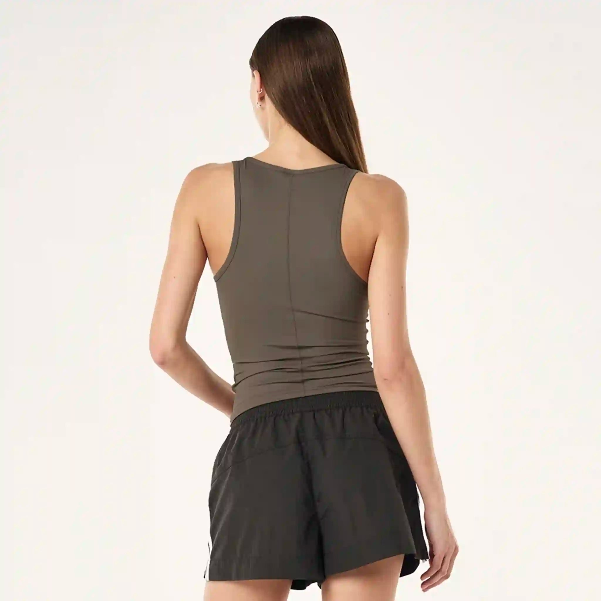 Woman wearing a sleeveless top and black skirt on a white background