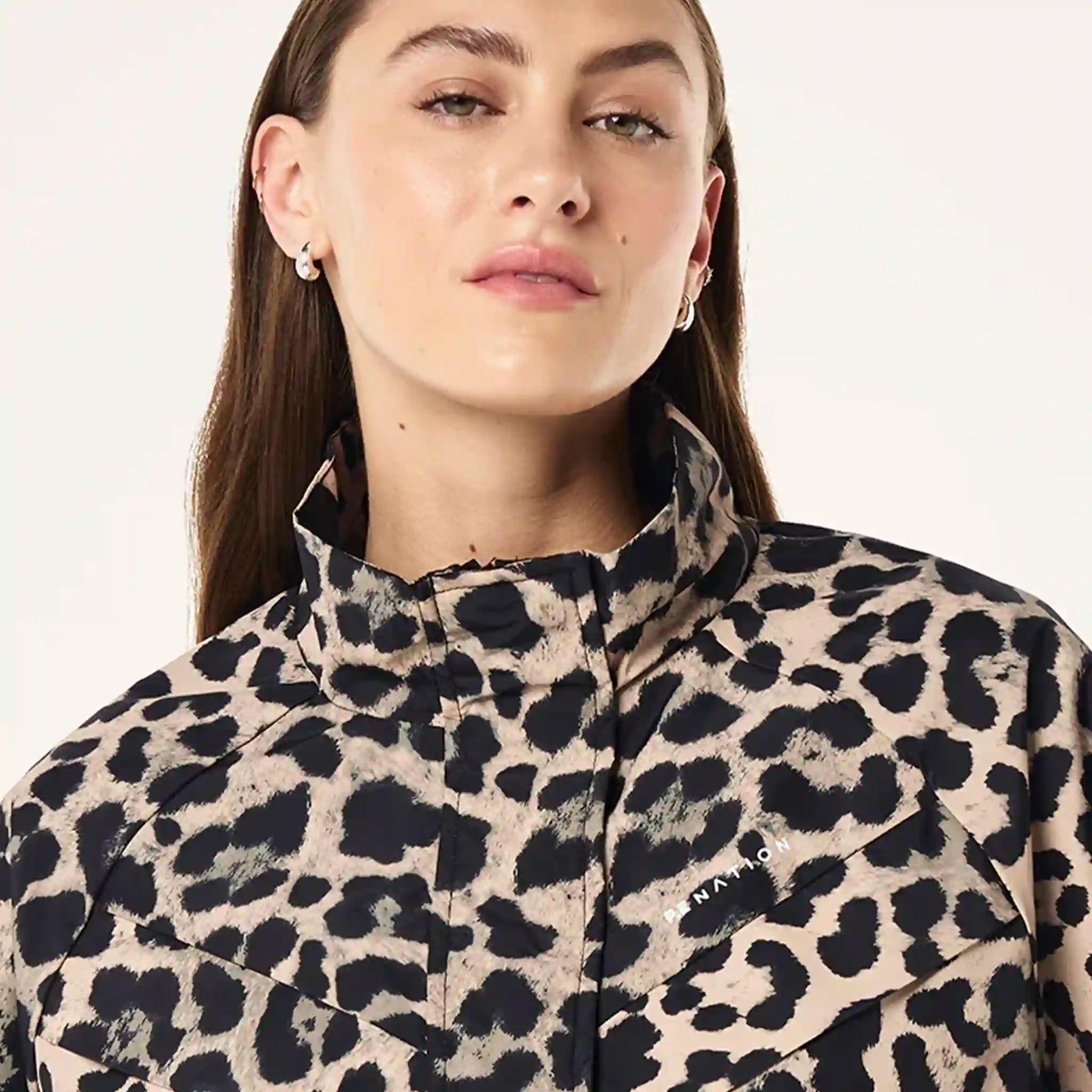 Person wearing a leopard print jacket on a  plain background