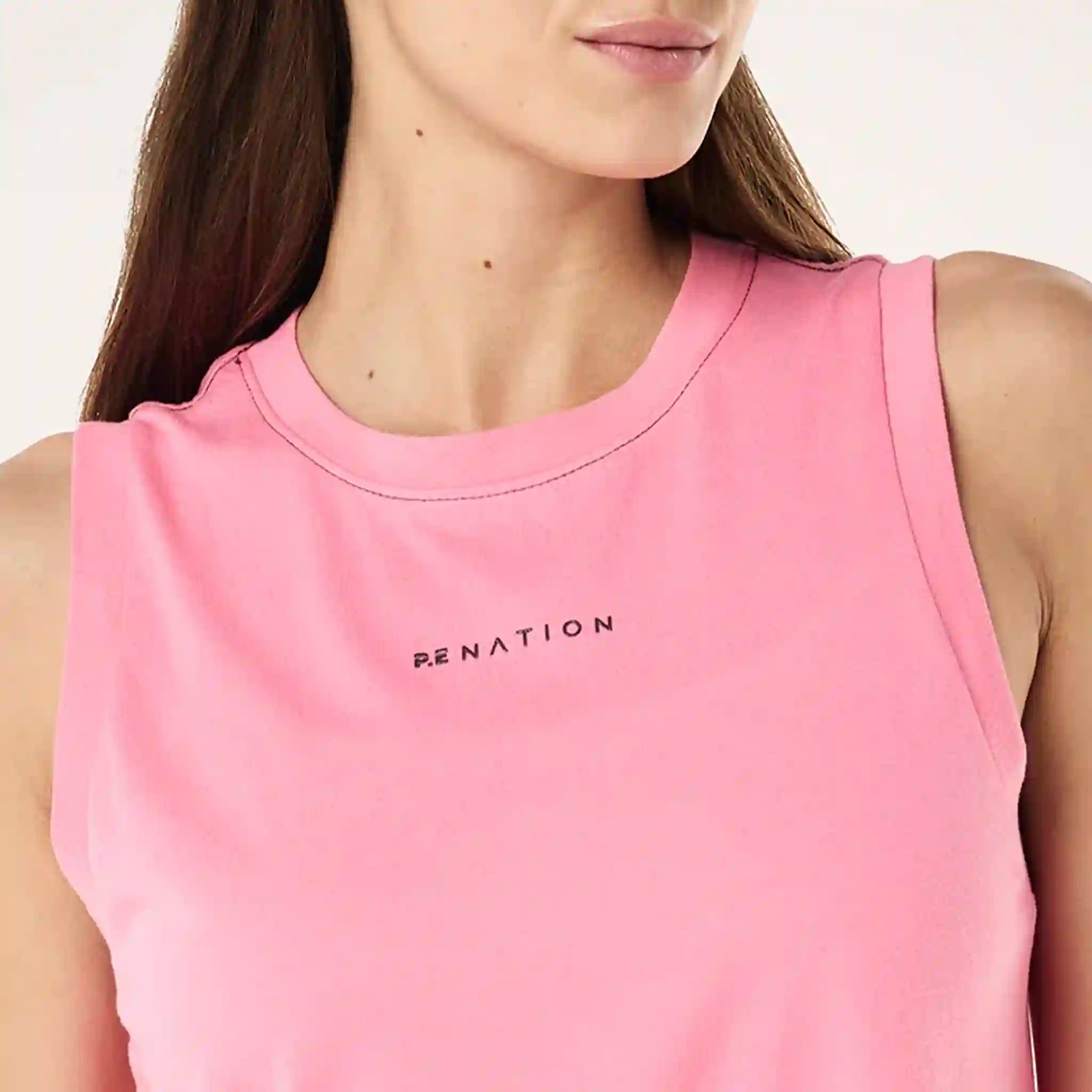 Pink sleeveless top with 'PE NATION' logo worn by a person
