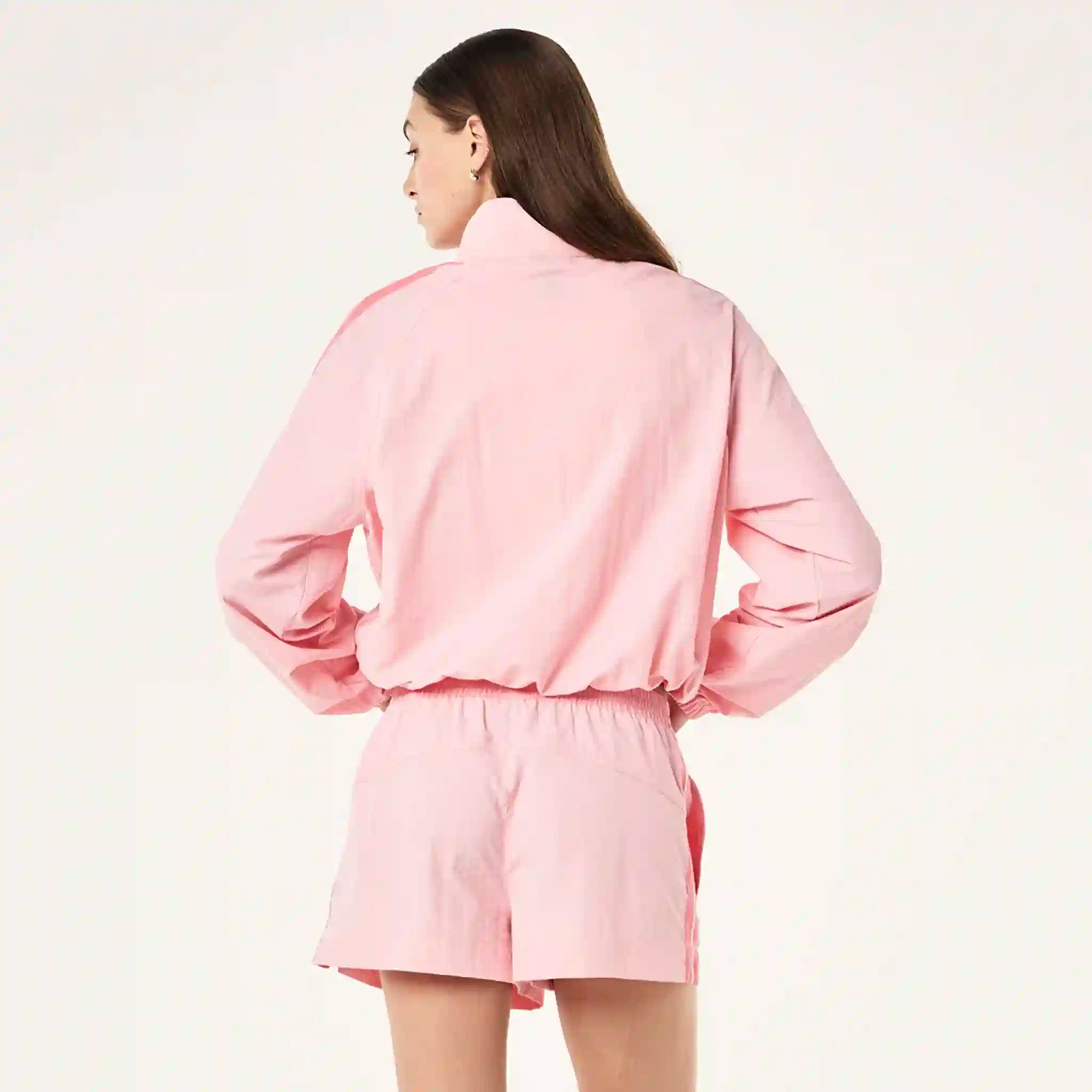 Person wearing a pink outfit on a light beige background